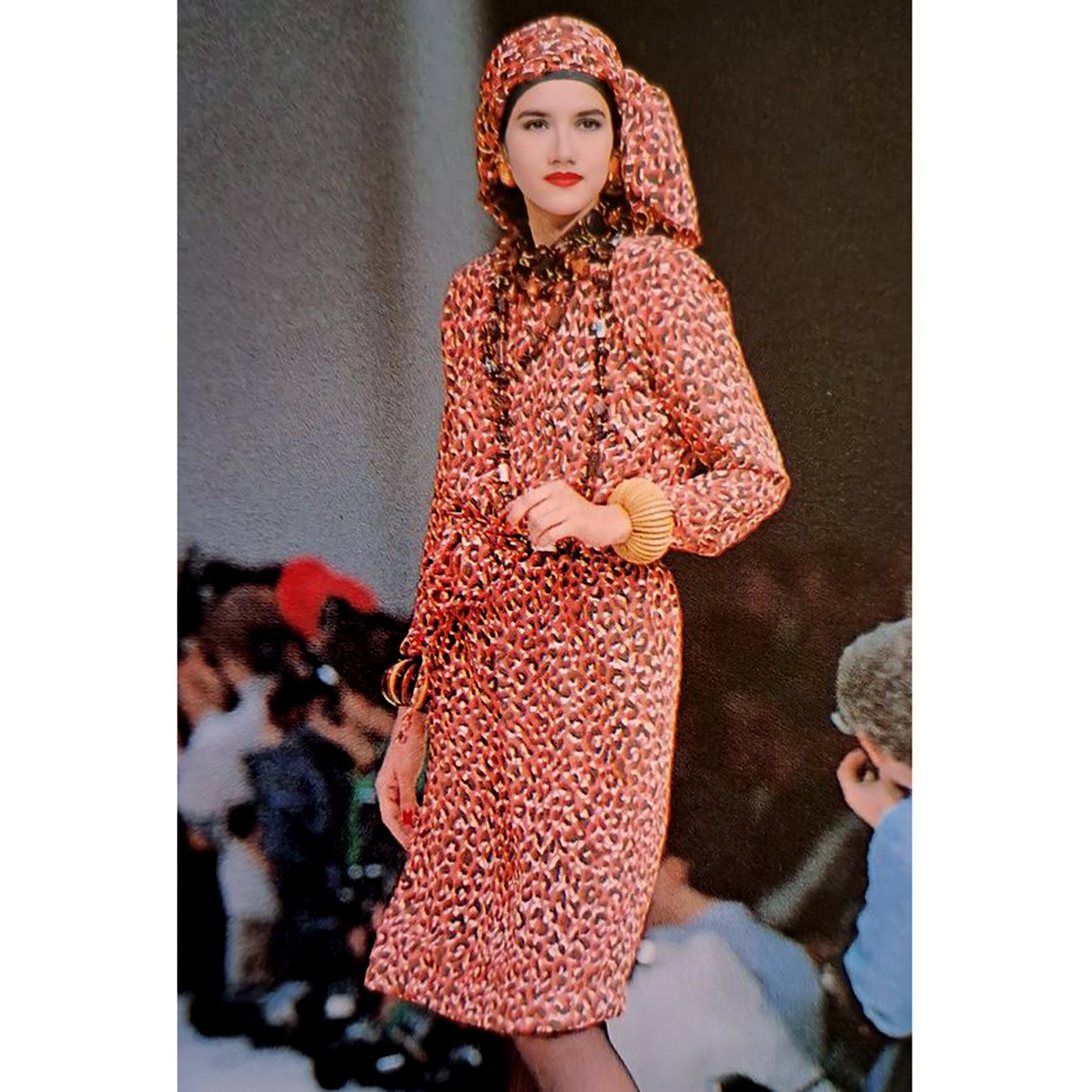 This is a fun Yves Saint Laurent leopard print silk dress from the YSL Spring/Summer 1989 runway collection. This lovely dress is in a playful salmon orange, brown and white leopard print, with a matching separate fabric sash belt.
The dress has the