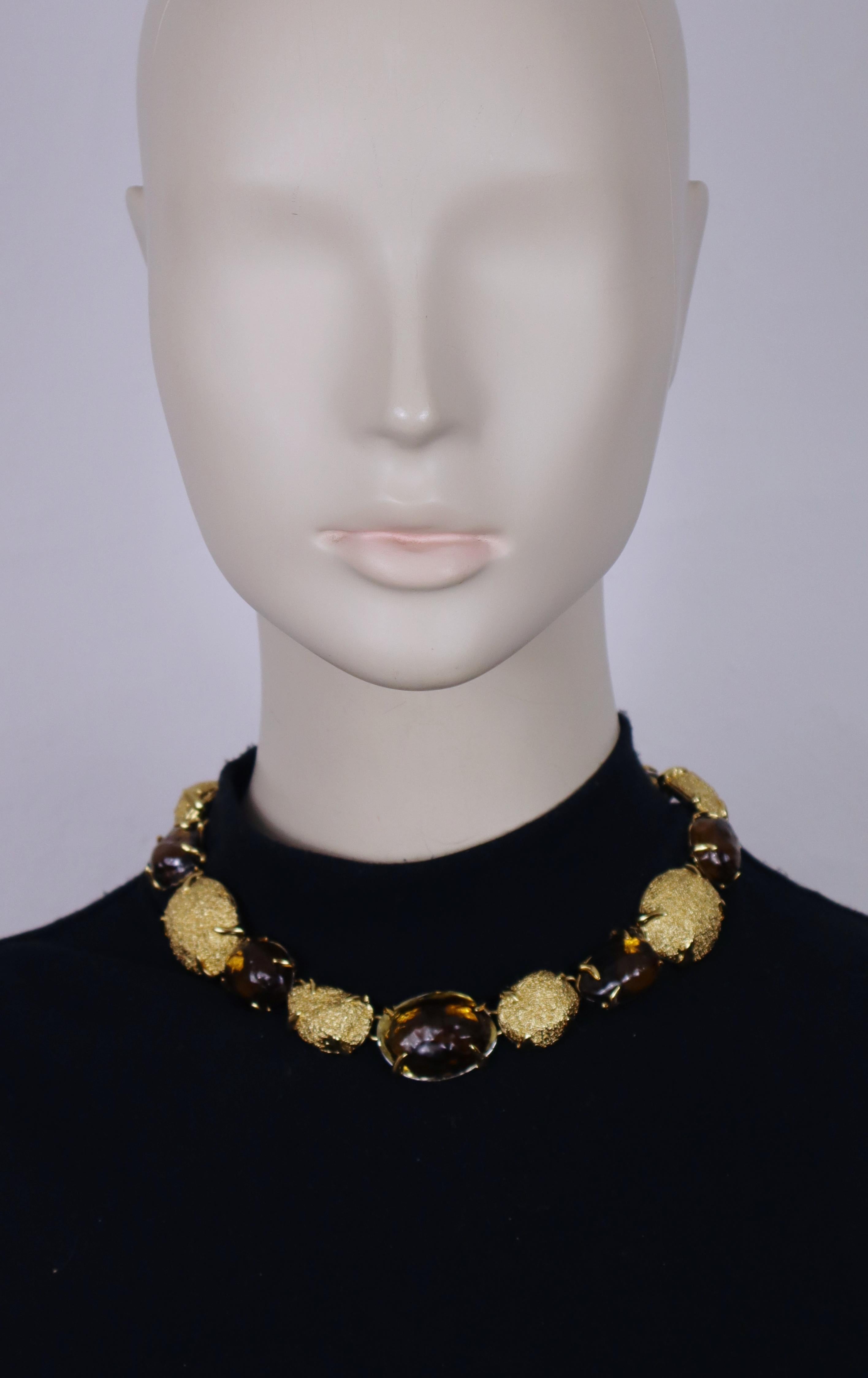Collana vintage di Yves Saint Laurent con cabochon in resina color ambra di forma irregolare e pepite ovali con montatura in oro.

Chiusura a levetta.
Lunghezza regolabile.

Impresso con la firma in corsivo Yves Saint Laurent sugli anelli a