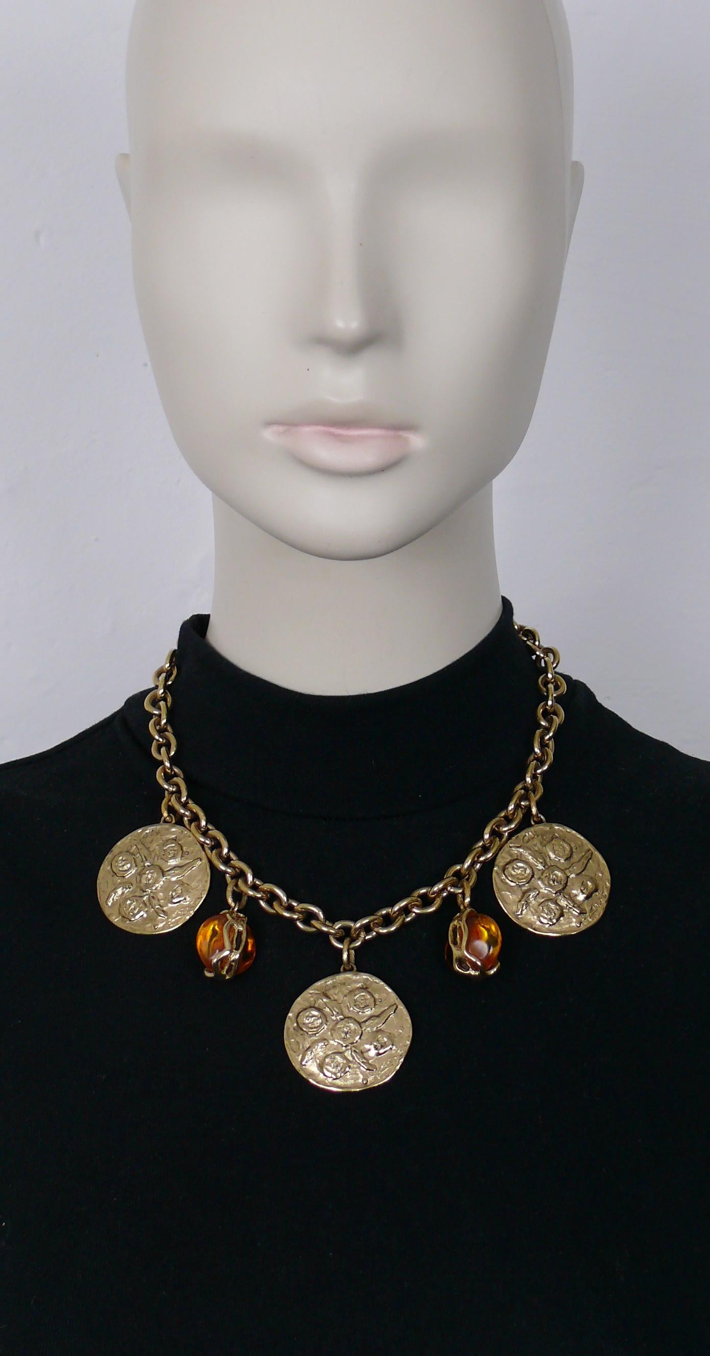 Collana a catena vintage in oro di Yves Saint Laurent con tre monete testurizzate e due gocce di resina arancione in una montatura in oro.

Chiusura a molla.
Lunghezza regolabile.

YSL in rilievo sulla chiusura.
Etichetta metallica appesa con la