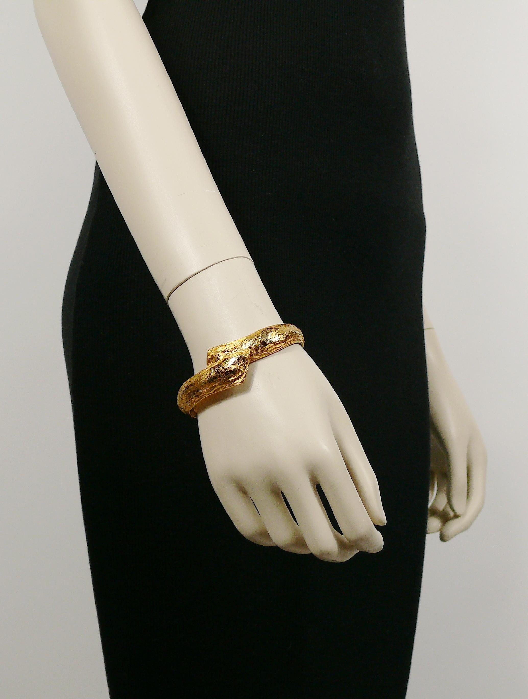 YVES SAINT LAURENT vintage distressed gold toned clamper bracelet.

Marked YSL Made in France.

Indicative measurements : inner measurements (without extension) approx. 6 cm x 4.5 cm (2.36 inches x 1.77 inches) / max width approx. 1.5 cm (0.59
