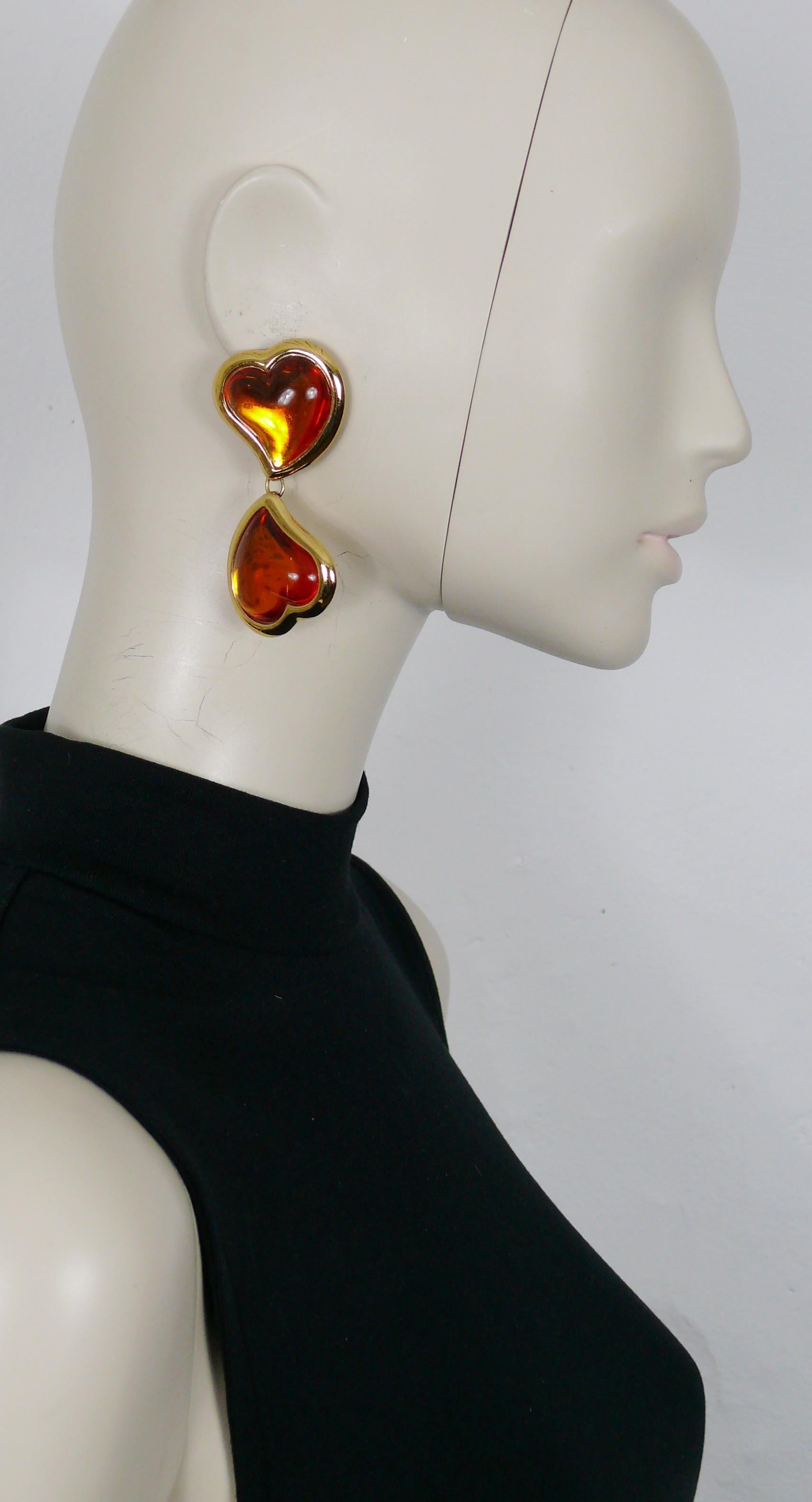 YVES SAINT LAURENT vintage dangling earrings (clip-on) featuring two orange resin cabochon hearts in a gold toned setting.

Embossed YSL Made in France.

Indicative measurements : height approx. 7.5 cm (2.95 inches) / max. width approx 3.4 cm (1.34