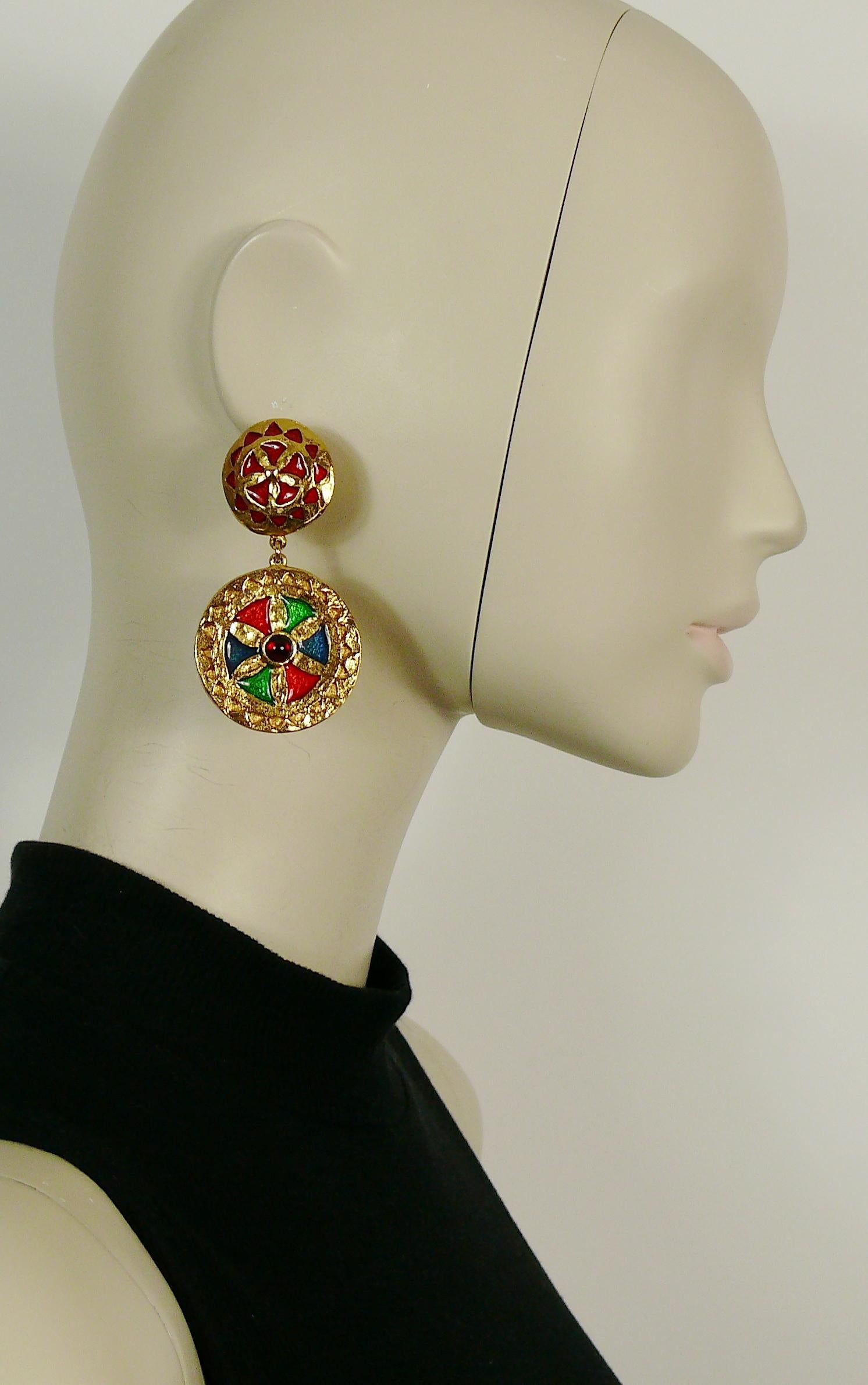 YVES SAINT LAURENT vintage gold toned dangling earrings featuring shields embellished with multicolored enamel and red glass cabochon.

Marked YSL.
Made in France.

Indicative measurements : height approx. 7.1 cm (2.80 inches) / max. diameter