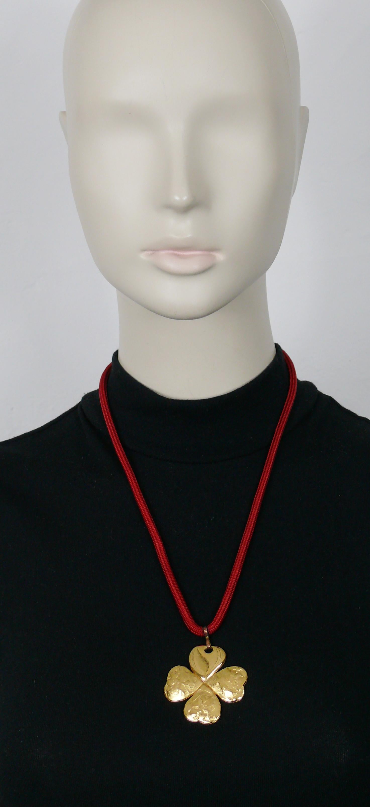 YVES SAINT LAURENT Vintage-Halskette mit vierblättrigem Kleeblatt-Anhänger in Goldton.

Rotes Seil.

Wird aufgesteckt (kein Verschlusssystem).
Einstellbare Länge (Schiebeherz).

Geprägtes YSL Made in France.
Auf dem verschiebbaren Herz ist die