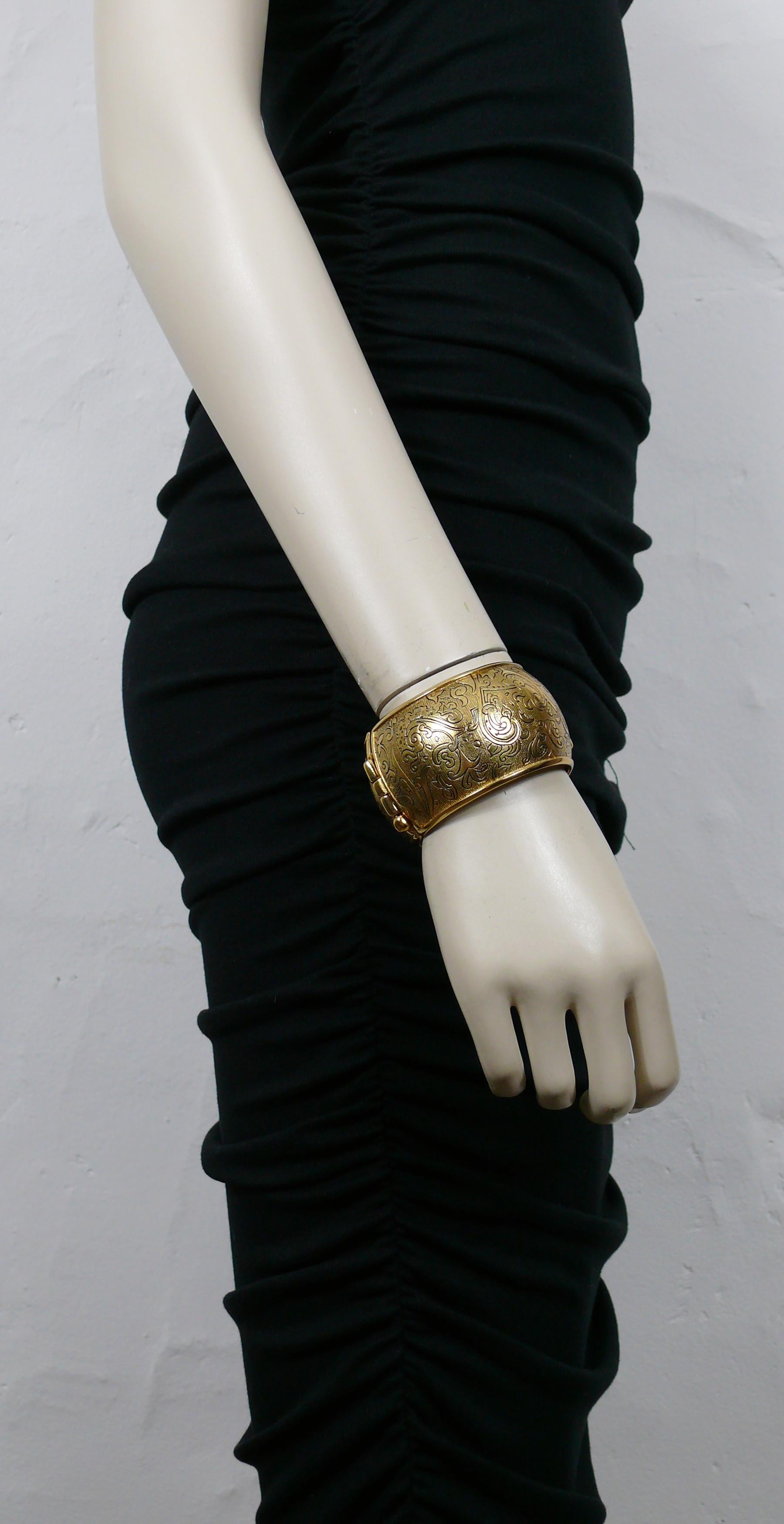 YVES SAINT LAURENT vintage gold tone cuff bracelet embossed with floral arabesques on a guilloche background.

Embossed YSL Made in France.

Indicative measurements : inner circumference approx. 17.59 cm (6.93 inches) / width approx. 4 cm (1.57