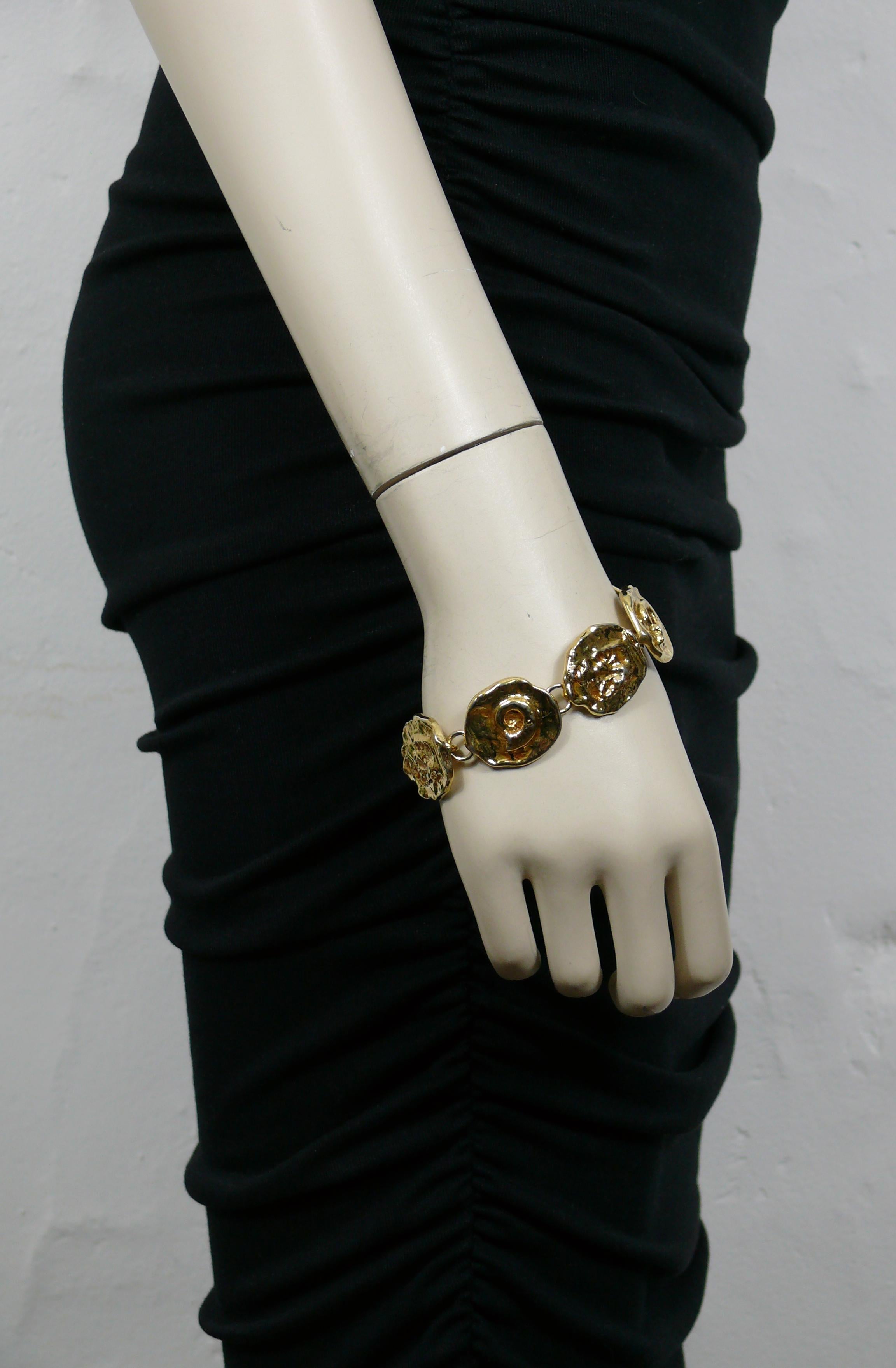 YVES SAINT LAURENT vintage gold tone bracelet featuring fossil motif medallion links.

Box clasp closure.

Embossed YSL Made in France.

Indicative measurements : length approx. 20 cm (7.87 inches) / medallion width approx. 2.2 cm (0.87