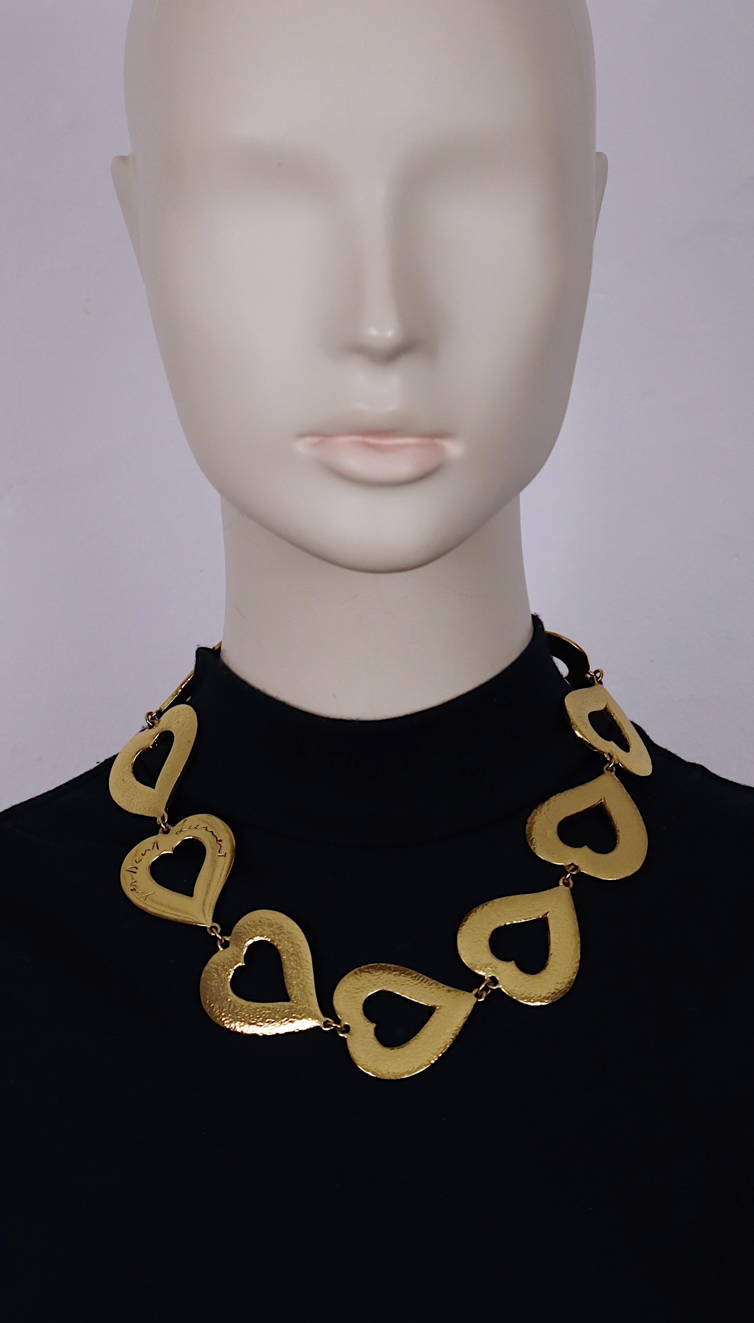 Collana vintage in tonalità oro di YVES SAINT LAURENT con maglie a cuore dalla texture massiccia e una maglia a cuore con la firma in corsivo di Yves Saint Laurent.

Chiusura ad alamari regolabile.

Con le firme in corsivo di Yves Saint Laurent