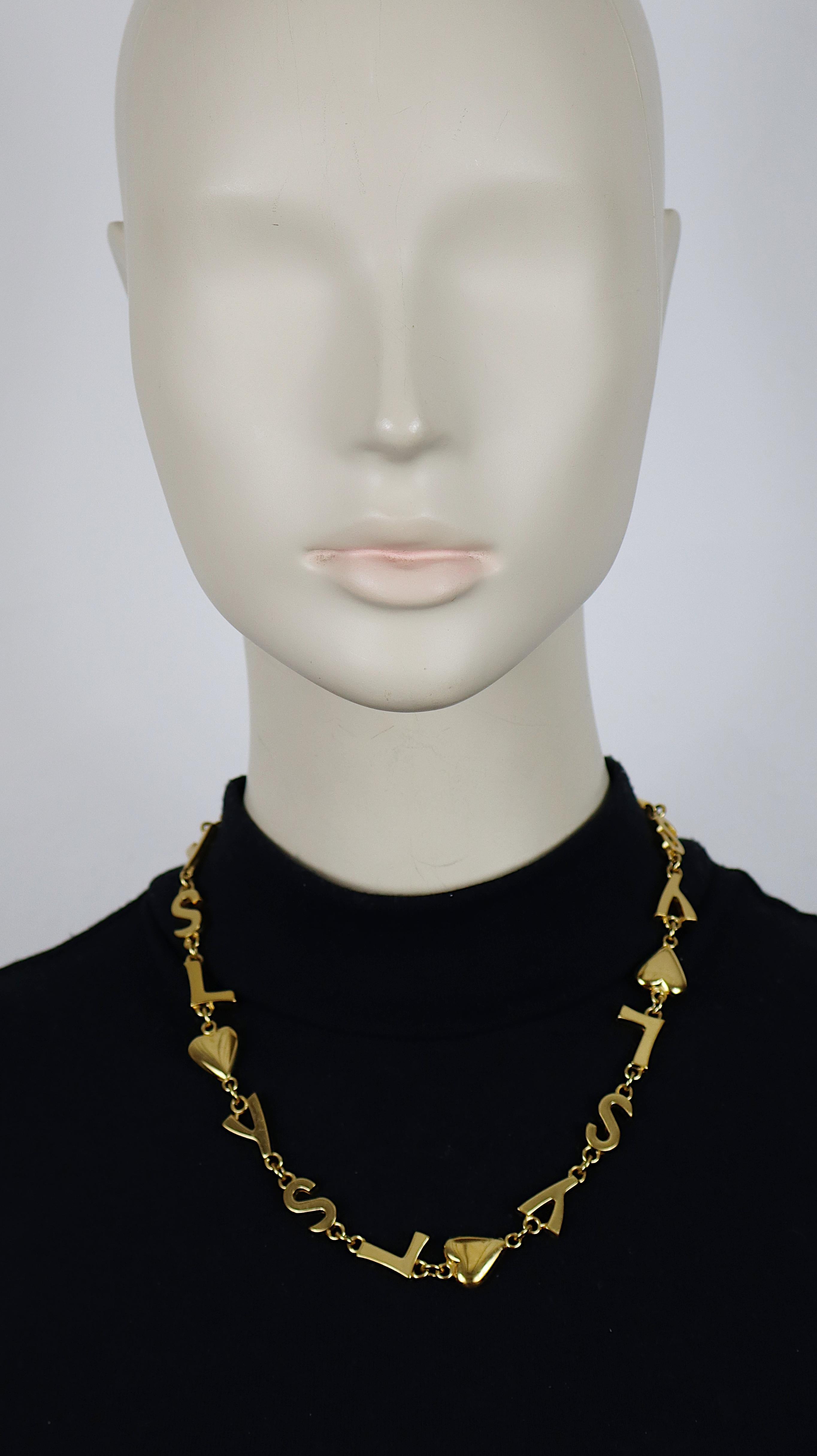 YVES SAINT LAURENT Vintage-Halskette in Goldton mit ikonischen YSL-Initialen, Herzen und Sternen als Glieder.

T-Bar-Verschluss und Kippschalter mit Herzchen.

Kursiver Schriftzug YVES SAINT LAURENT, geprägt auf den Knöpfen mit
