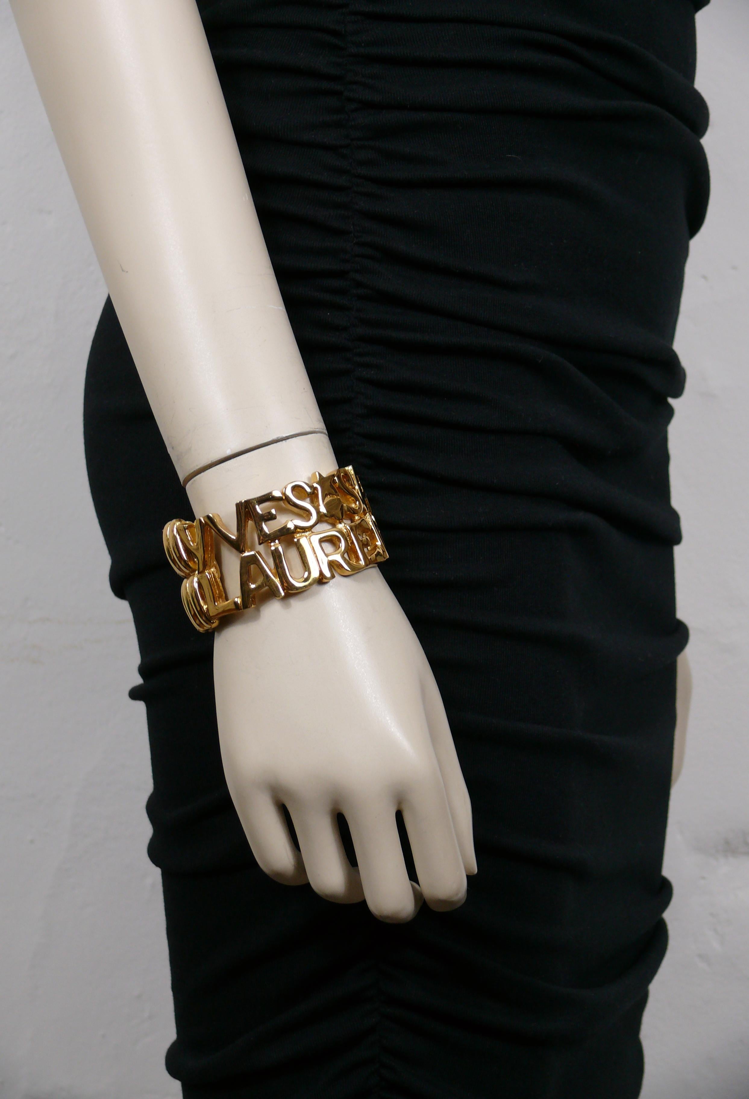 YVES SAINT LAURENT vintage gold tone cuff bracelet featuring spelled YVES SAINT LAURENT letters, hearts and stars.

Hinge spring closure.

Embossed YSL Made in France.

Indicative measurements : inner max. measurements approx. 5.7 cm x 4.6 cm (2.24