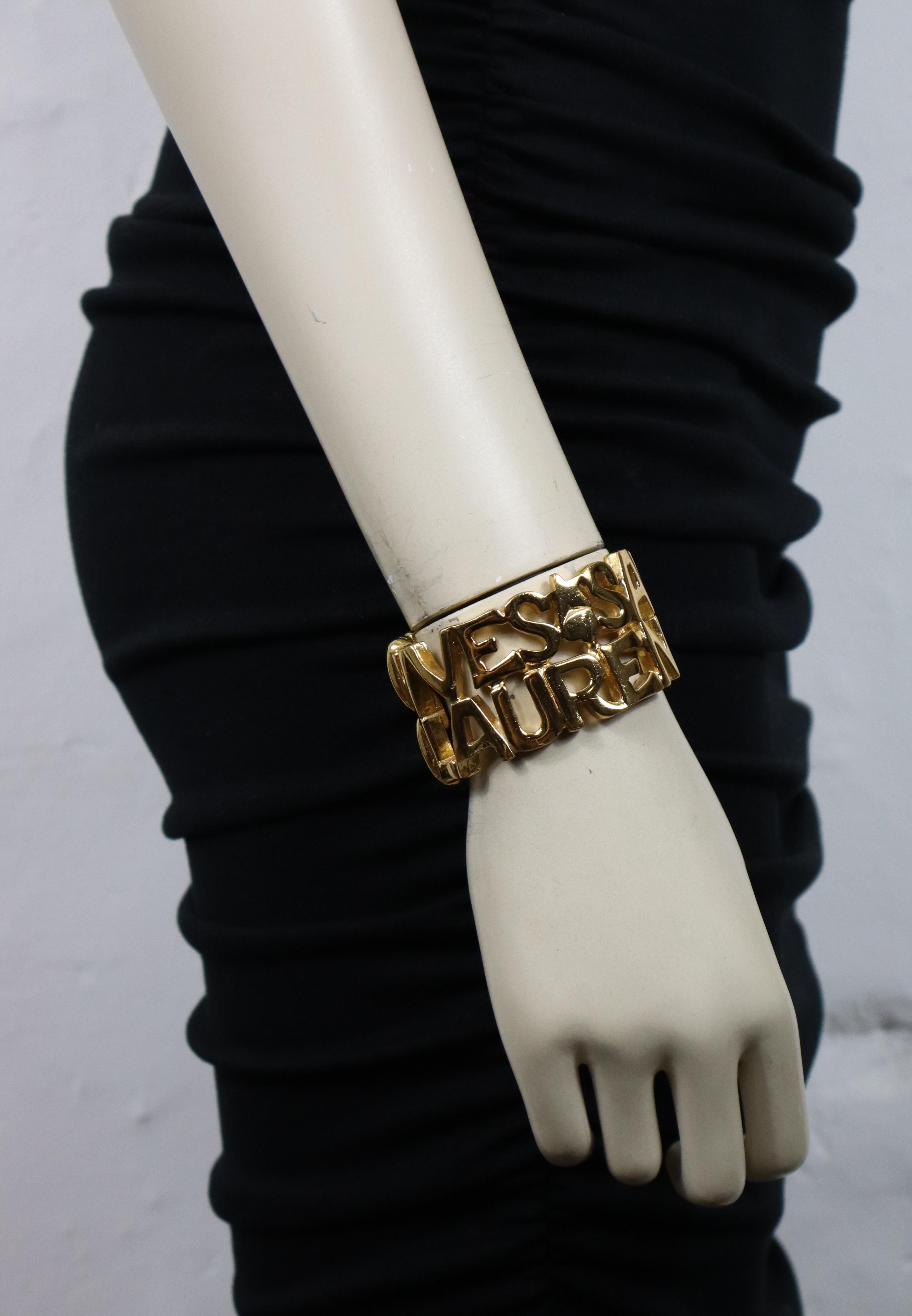 YVES SAINT LAURENT vintage gold tone cuff bracelet featuring spelled YVES SAINT LAURENT letters, hearts and stars.

Clamper closure.

Embossed YSL Made in France.

Indicative measurements : inner max. measurements approx. 5.1 cm x 4.3 cm (2 inches x