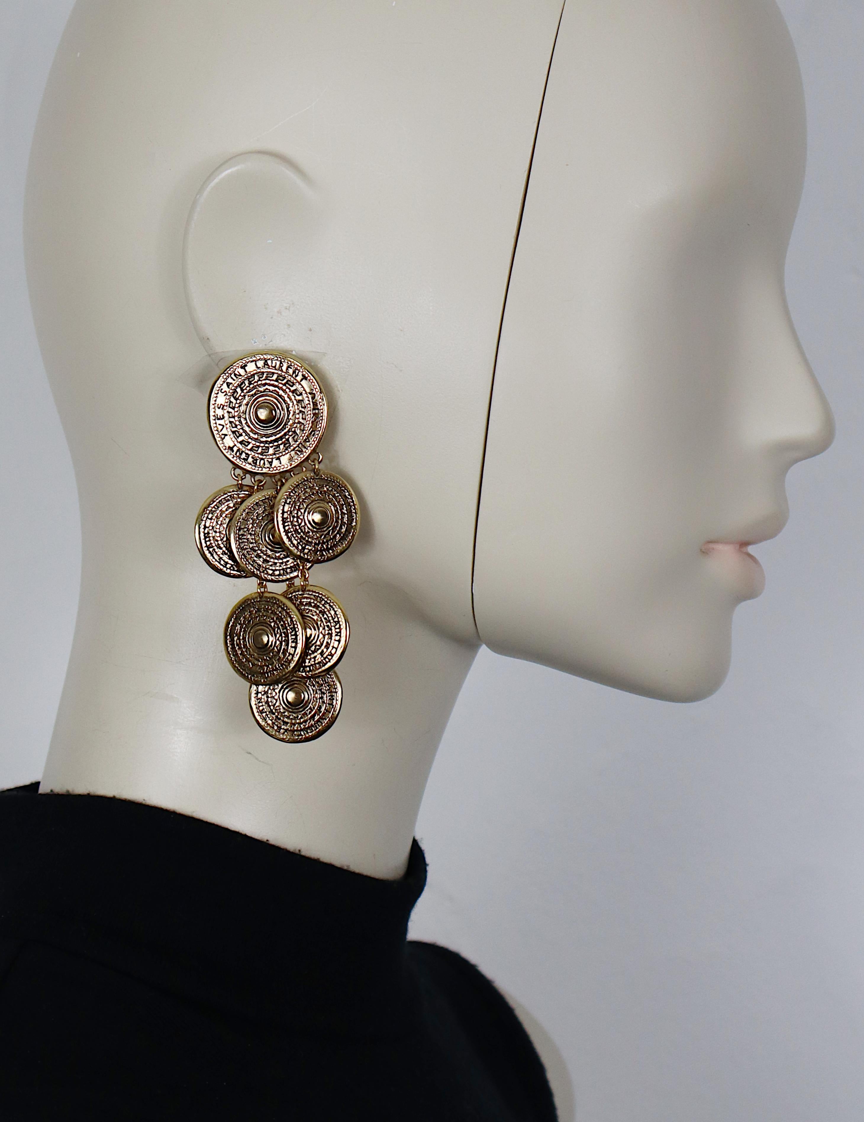YVES SAINT LAURENT vintage antiqued gold tone dangling earrings (clip-on) featuring medal charms embossed YVES SAINT LAURENT.

Embossed YSL.

Indicative measurements : max. height approx. 8.6 cm (3.39 inches) / max. width approx. 4.2 cm (1.65