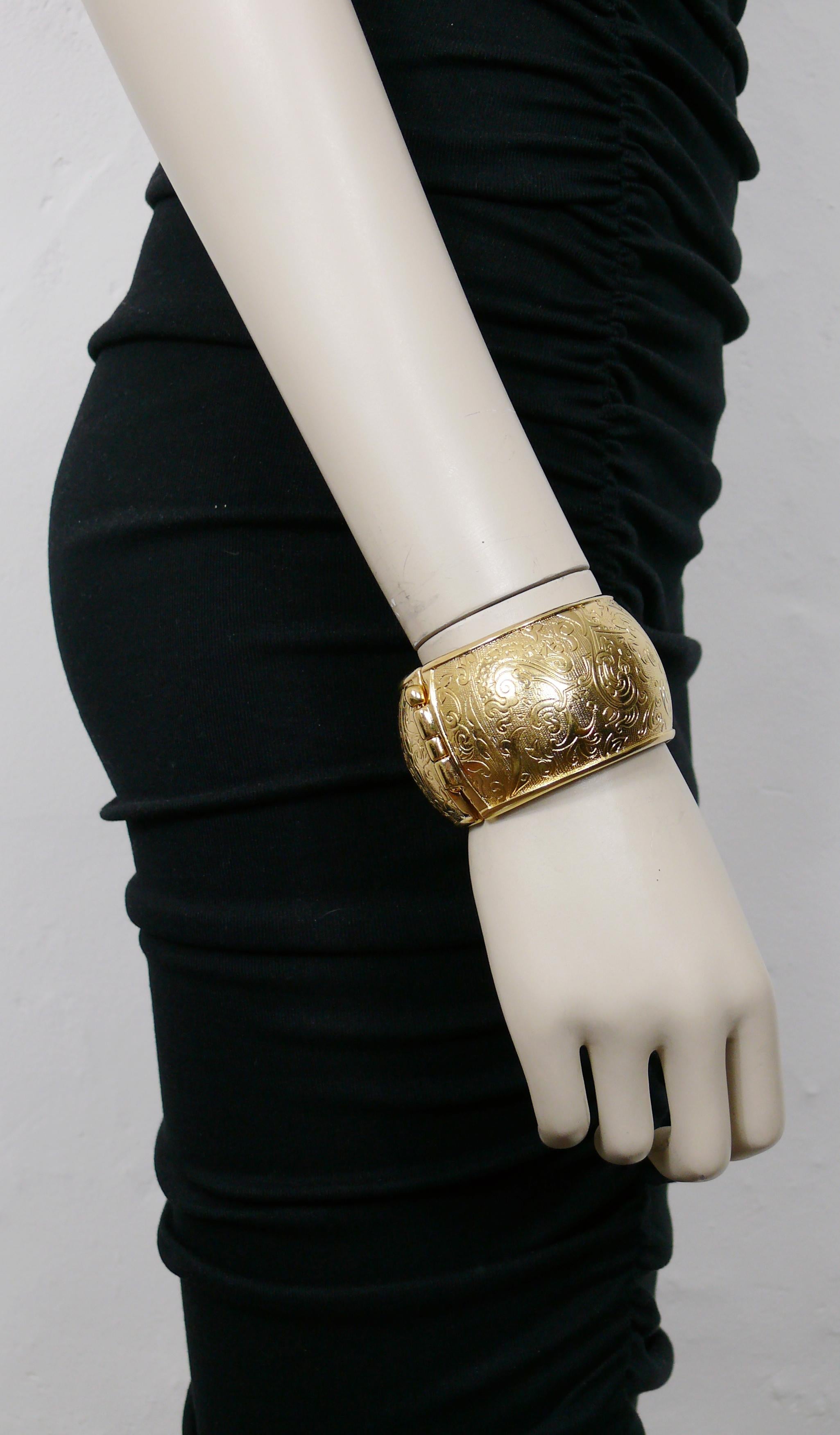 YVES SAINT LAURENT Vintage gold toned cuff bracelet embossed with floral arabesques on a guilloche background.

Embossed YSL Made in France.

Indicative measurements : inner max. measurements approx. 5.6 cm x 5.6 cm (2.20 inches x 2.20 inches) /