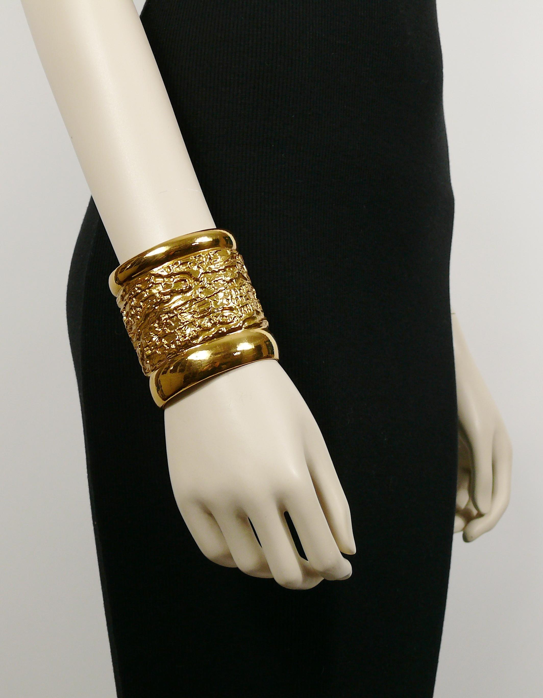 YVES SAINT LAURENT vintage gold toned lava textured wide cuff bracelet.

Embossed YSL Made in France.

Indicative measurements : inner measurements approx. 6 cm x 4.8 cm (2.36 inches x 1.89 inches) / width approx. 7 cm (2.76 inches).

NOTES
- This