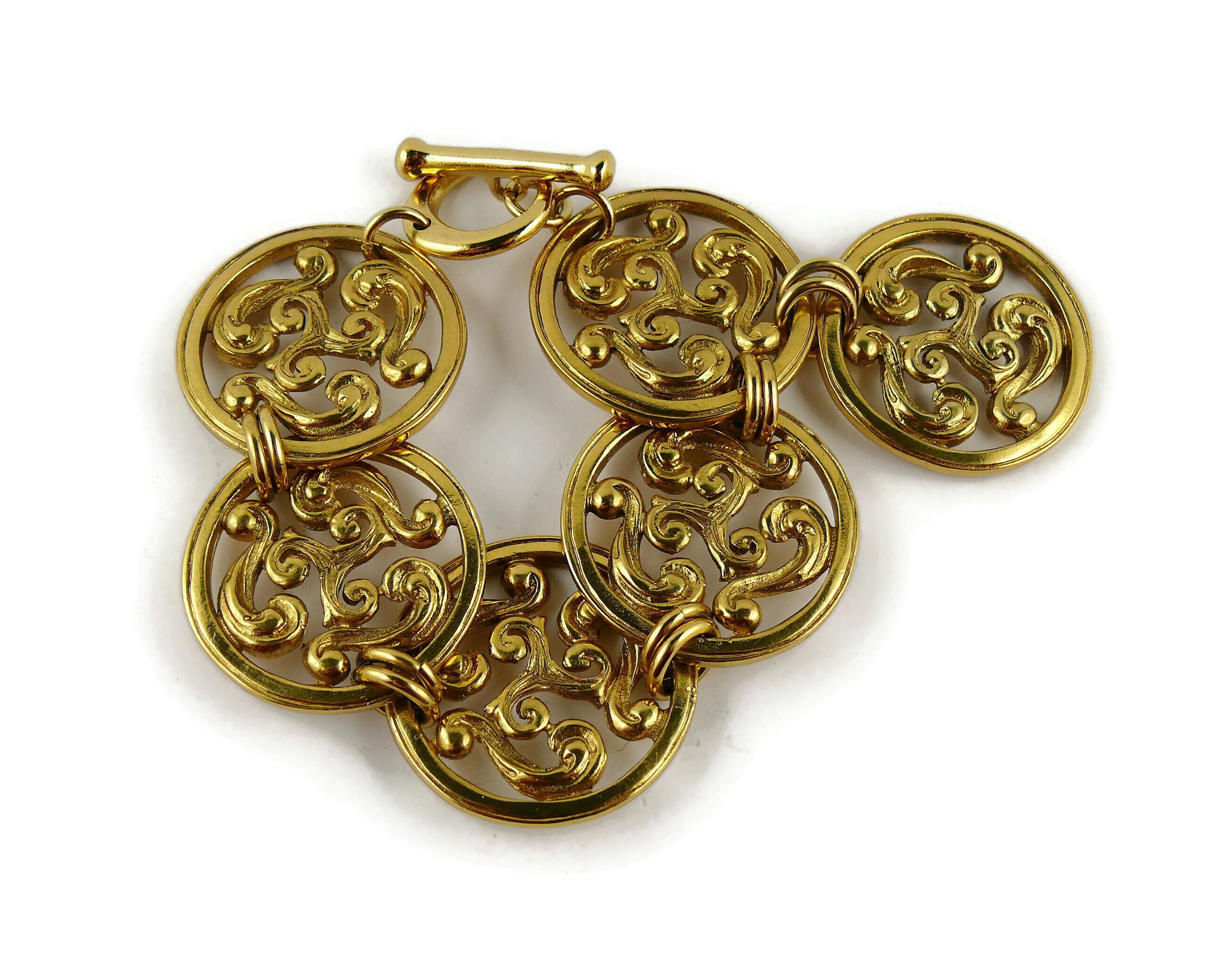 YVES SAINT LAURENT vintage gold toned bracelet and clip-on earrings set featuring an openwork scroll design.

Both earrings are embossed YSL Made in France.
Matching bracelet is unmarked.

Indicative measurements : earrings diameter approx. 4.4 cm