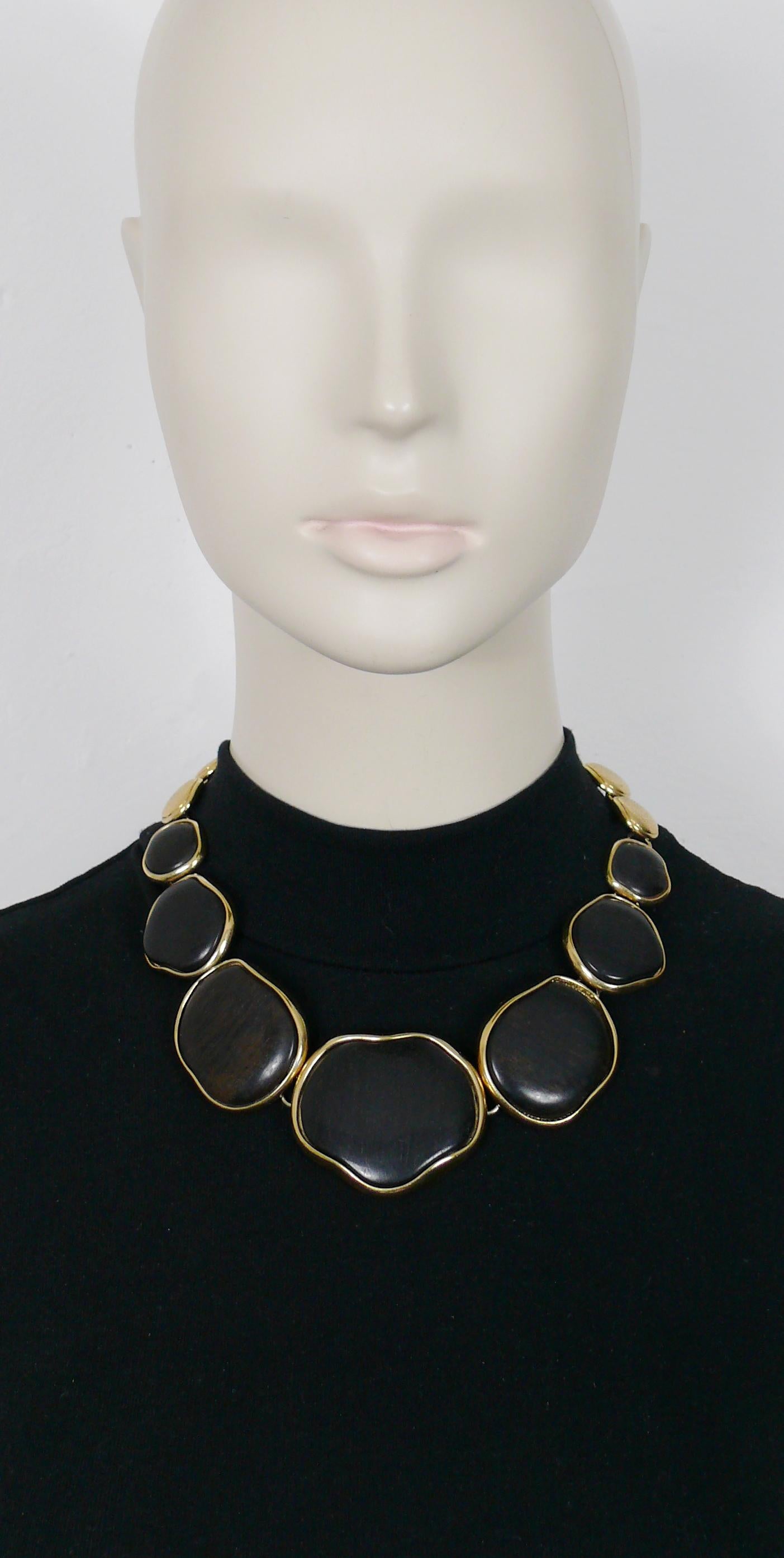 YVES SAINT LAURENT vintage choker necklace featuring irregular shaped graduated wood and gold toned metal discs.

Adjustable S hook closure.

Embossed YSL Made in France.

Indicative measurements : adjustable length from approx. 41 cm (16.14 inches)