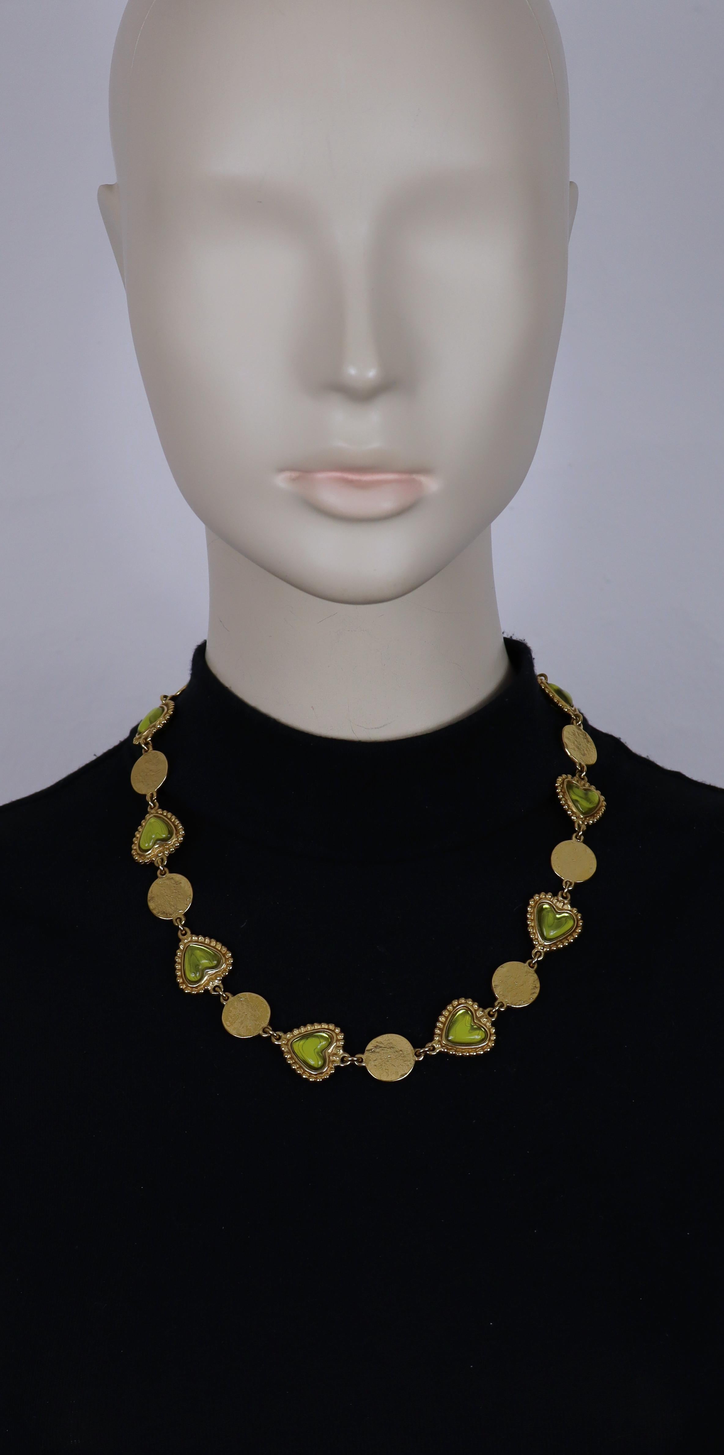 YVES SAINT LAURENT vintage gold tone necklace featuring textured coins alterning with heart links embellished with green resin cabochons.

Adjustable toggle clasp.

Embossed YSL Made in France.
Embossed with the cursive YVES SAINT LAURENT signature