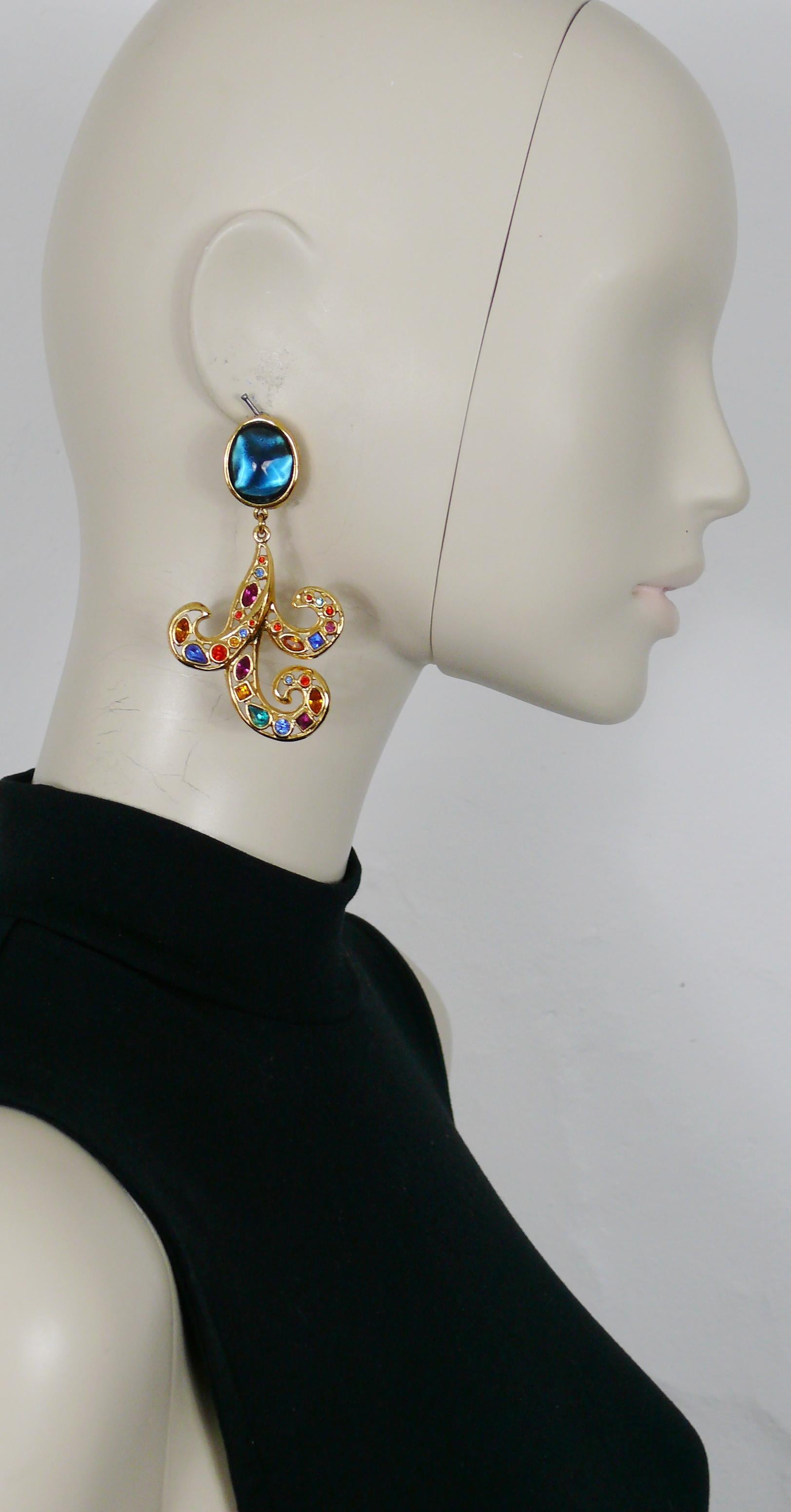 YVES SAINT LAURENT vintage gold toned dangling earrings (clip on) featuring a blue resin cabochon top and an openwork arabesque with multicolored crystal embellishement.

Embossed YSL Made in France.

Indicative measurements : max. height 8.2 cm