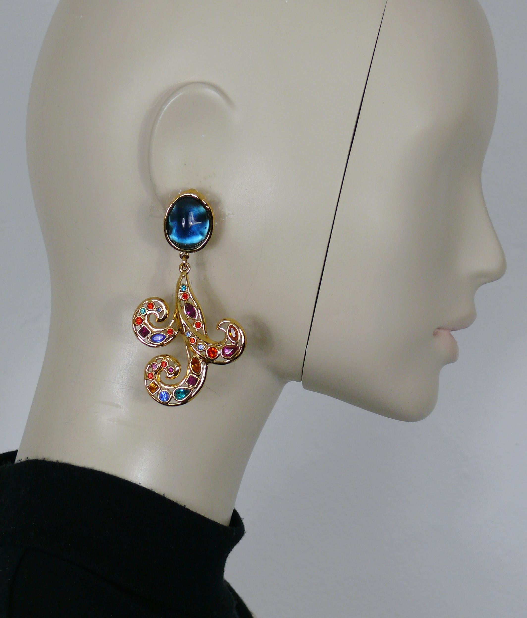 YVES SAINT LAURENT vintage gold tone dangling earrings (clip on) featuring a blue resin cabochon top and an openwork arabesque with multicolored crystal embellishement.

Embossed YSL Made in France.

Indicative measurements : max. height 8.2 cm