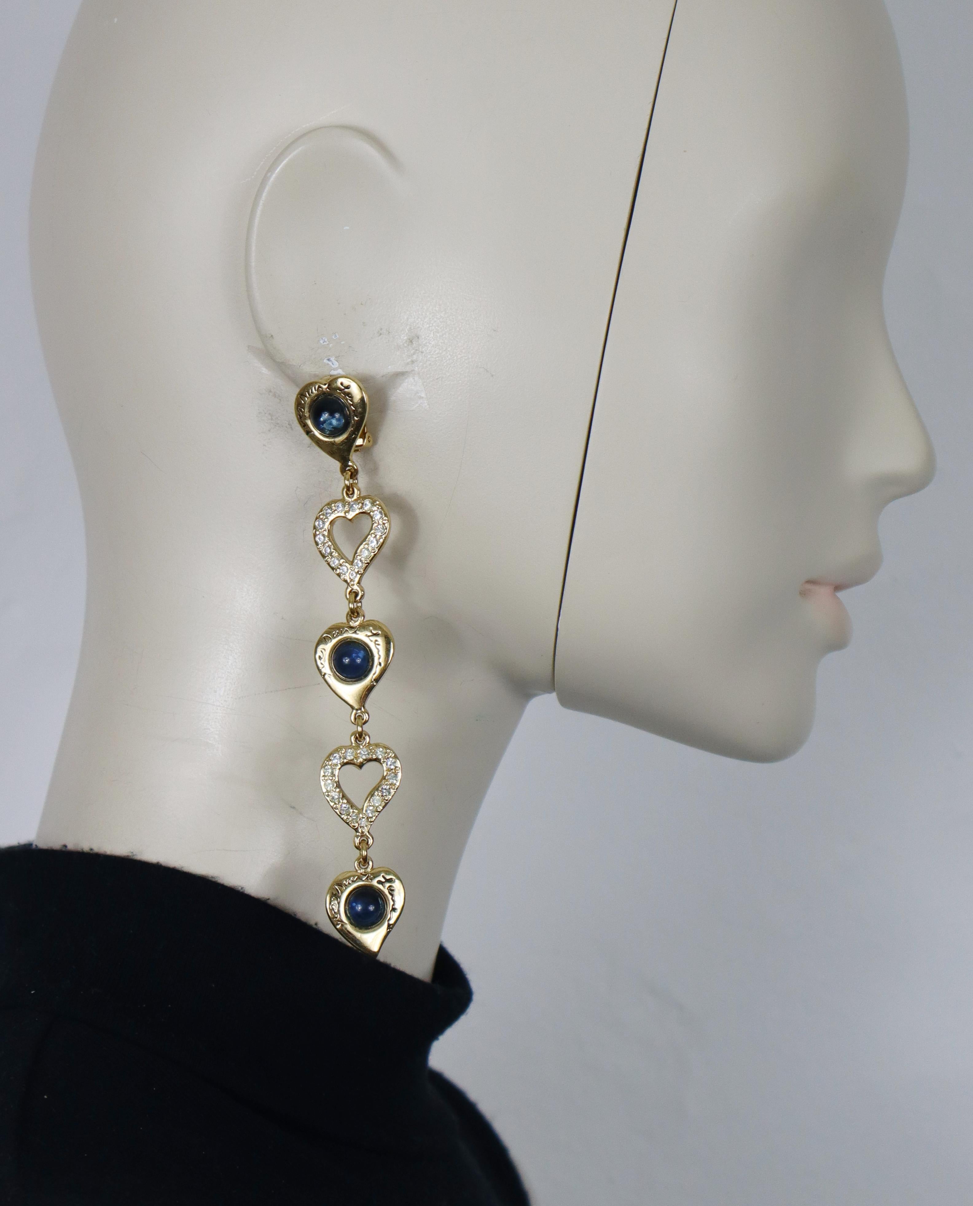 YVES SAINT LAURENT vintage gold tone dangle earrings (clip-on) featuring cascading hearts embellished with blue glass cabochons and clear crystals.

Embossed with YVES SAINT LAURENT cursive signatures.

Indicative measurements : height approx. 11.5