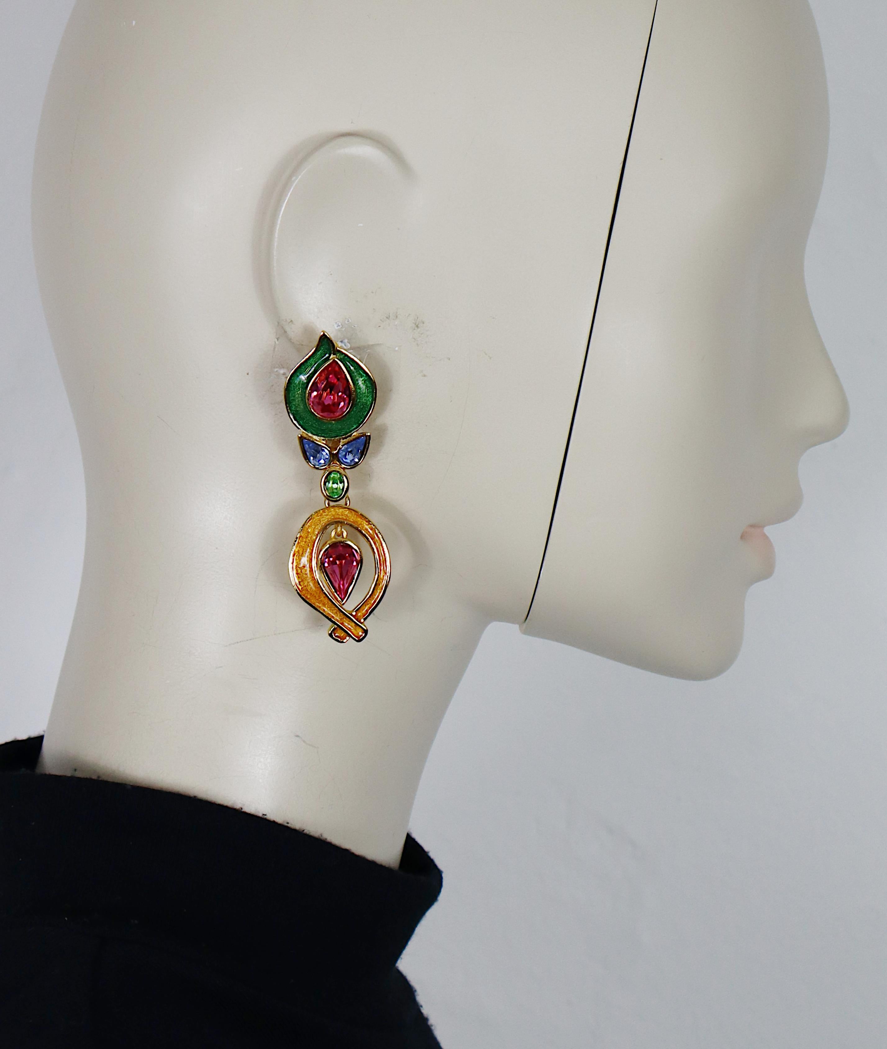 Pendientes colgantes vintage YVES SAINT LAURENT en tono dorado (con clip) adornados con esmalte multicolor y cristales.

Estampado YSL Made in France.

Medidas orientativas: altura máxima aprox. 7,5 cm / anchura máxima aprox. 2,3 cm.

Peso por