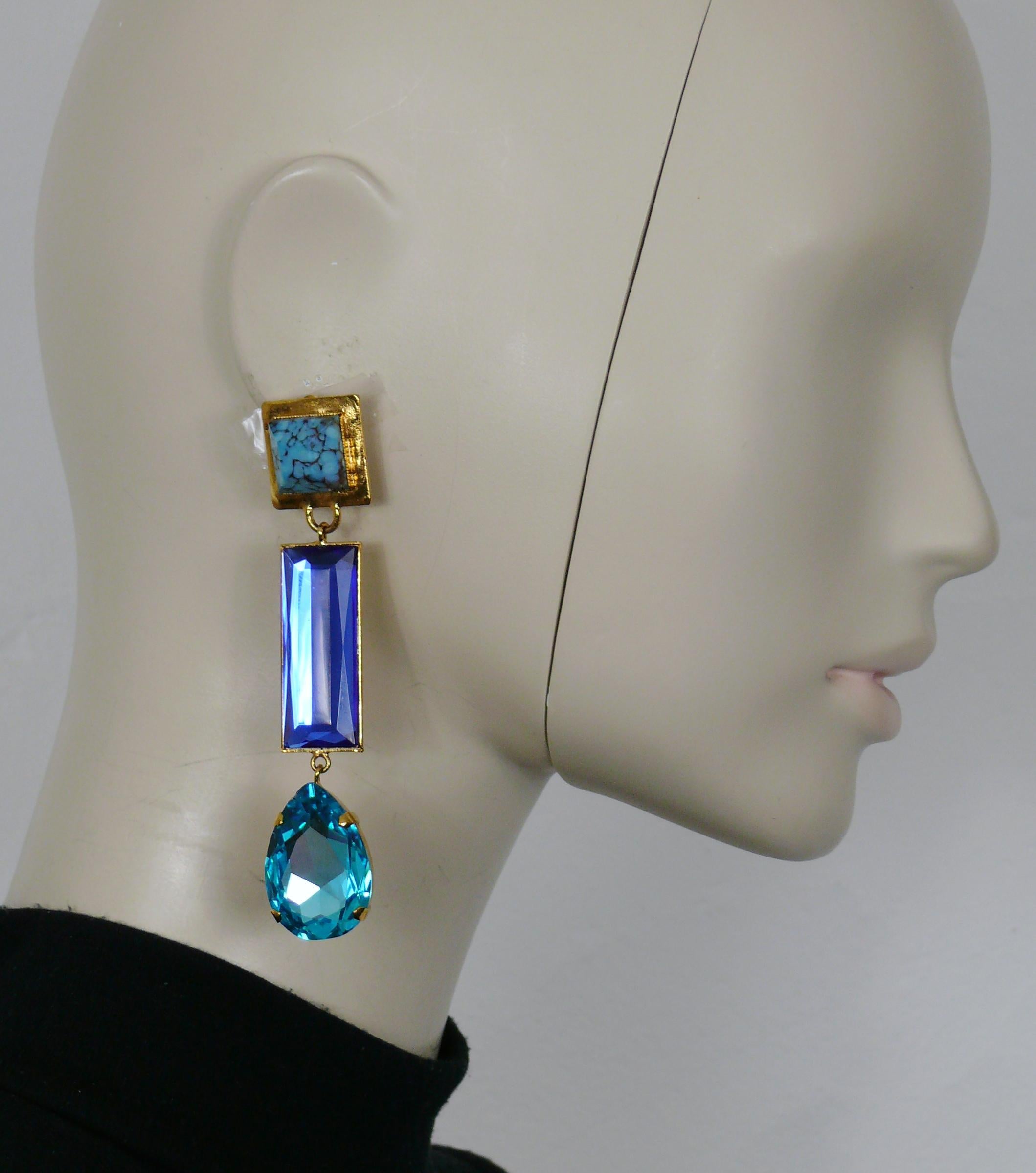 Boucles d'oreilles pendantes (clip-on) vintage YVES SAINT LAURENT en ton or, ornées d'un faux cabochon turquoise et de cristaux bleus.

Embossé YSL.

Mesures indicatives : hauteur env. 10 cm (3.94 inches) / largeur max. env. 2 cm (0.79