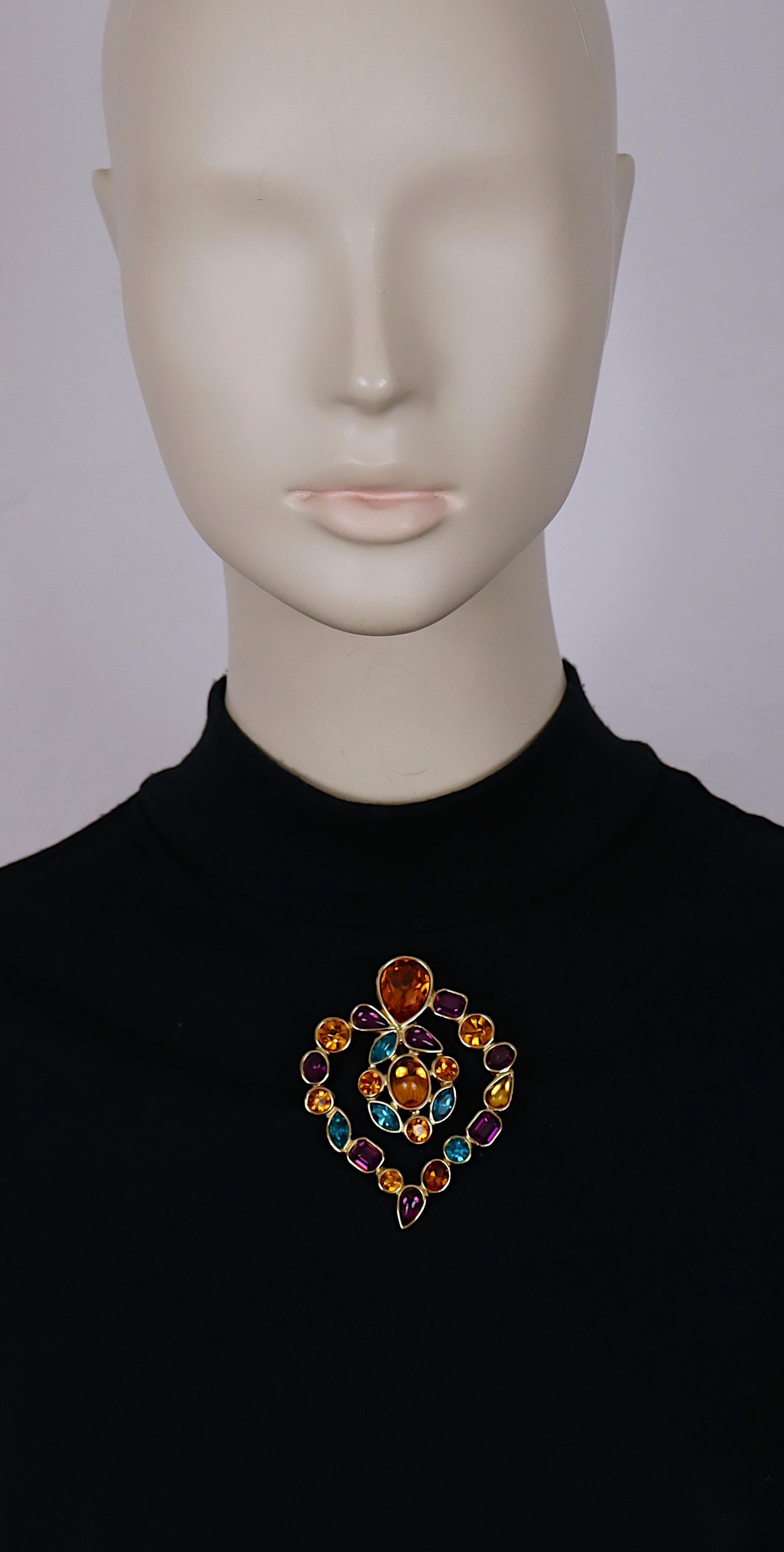 Broche/pendentif en forme de coeur en or vintage d'Yves Saint Laurent, orné de cristaux multicolores et de cabochons en verre.

Peut être porté en broche ou en pendentif.

Gaufrage YSL Made in France.

Mesures indicatives : hauteur max. env. 7,4 cm