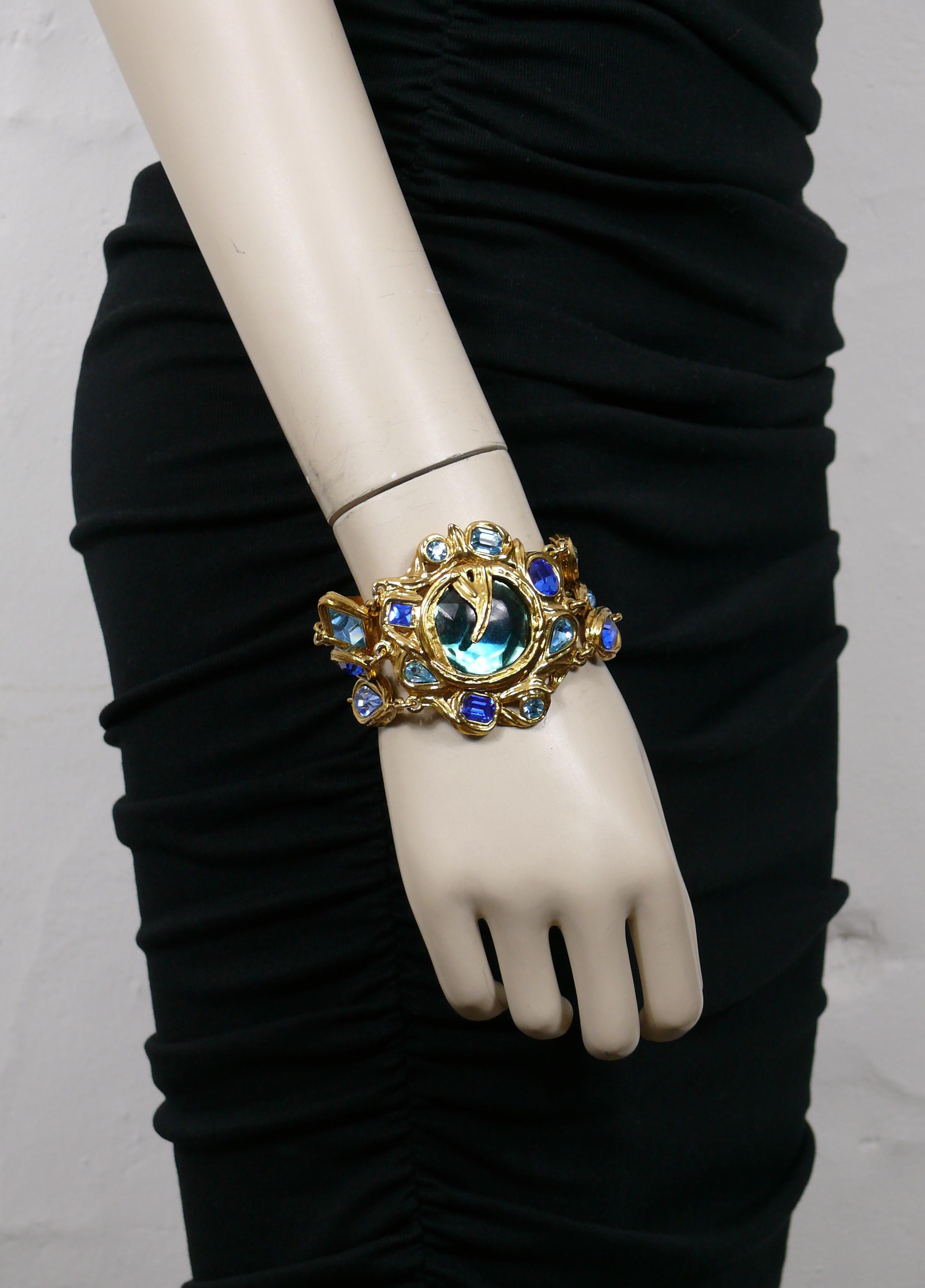 YVES SAINT LAURENT vintage three strand gold tone link CADIX bracelet embellished with blue shade crystals and a large blue resin cabochon at the center of the central medallion.

Secure clasp closure.

Embossed YSL Made in France.

Indicative