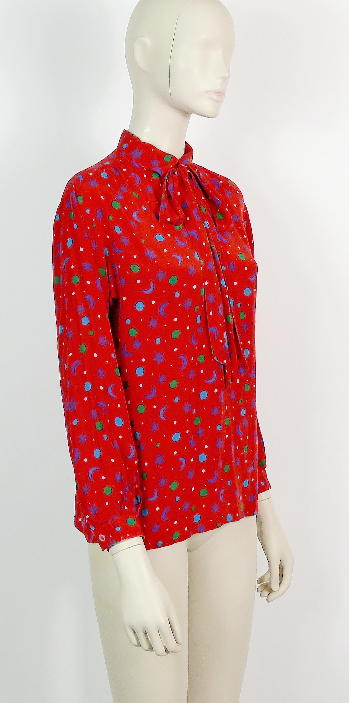 YVES SAINT LAURENT vintage red silk blouse featuring a multicolored suns-crescent moons-stars-dots print and a lavallière neck tie.

Slips on (no button closure down the front).
Cuff buttoning.

Label reads SAINT LAURENT RIVE GAUCHE Paris.
Made in