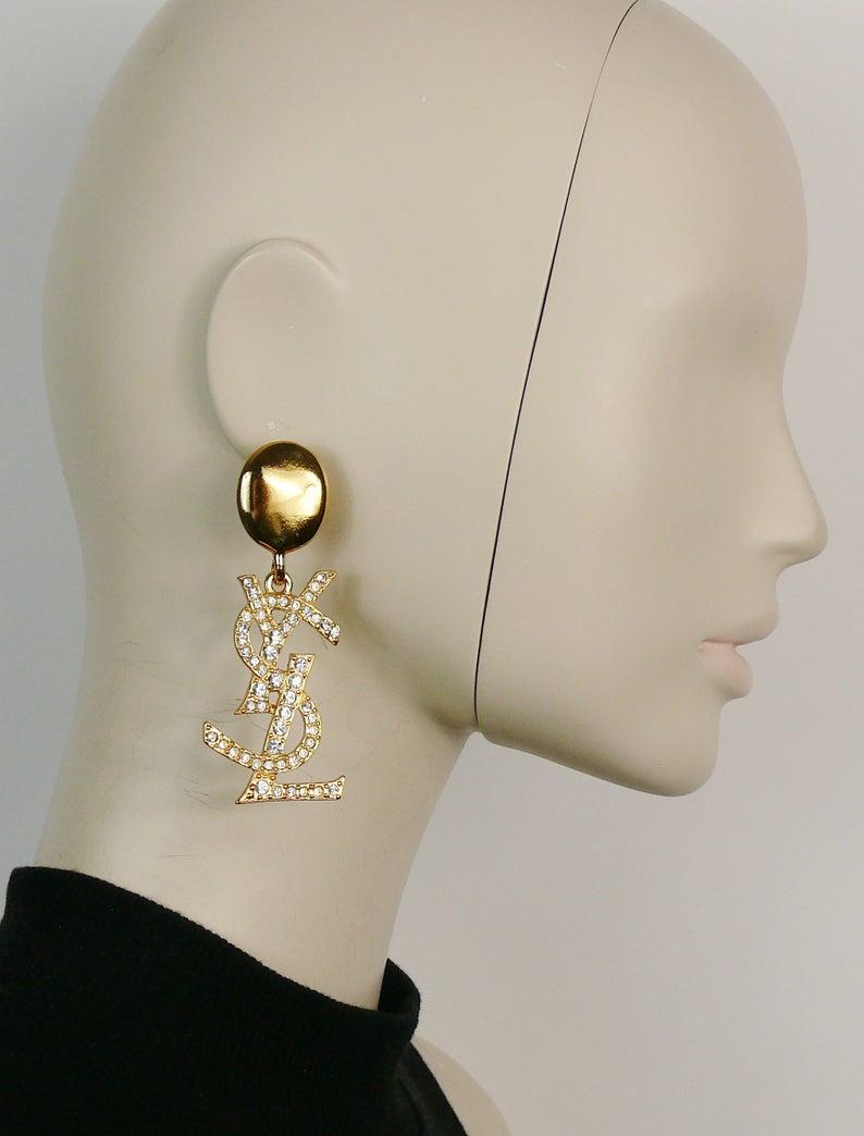 YVES SAINT LAURENT vintage rare massive gold toned dangling earrings (clip-on) featuring YSL monogram embellished with clear crystals.

Marked YSL Made in France.

Indicative measurements : height approx. 8 cm (3.15 inches) / max. width approx. 2.6