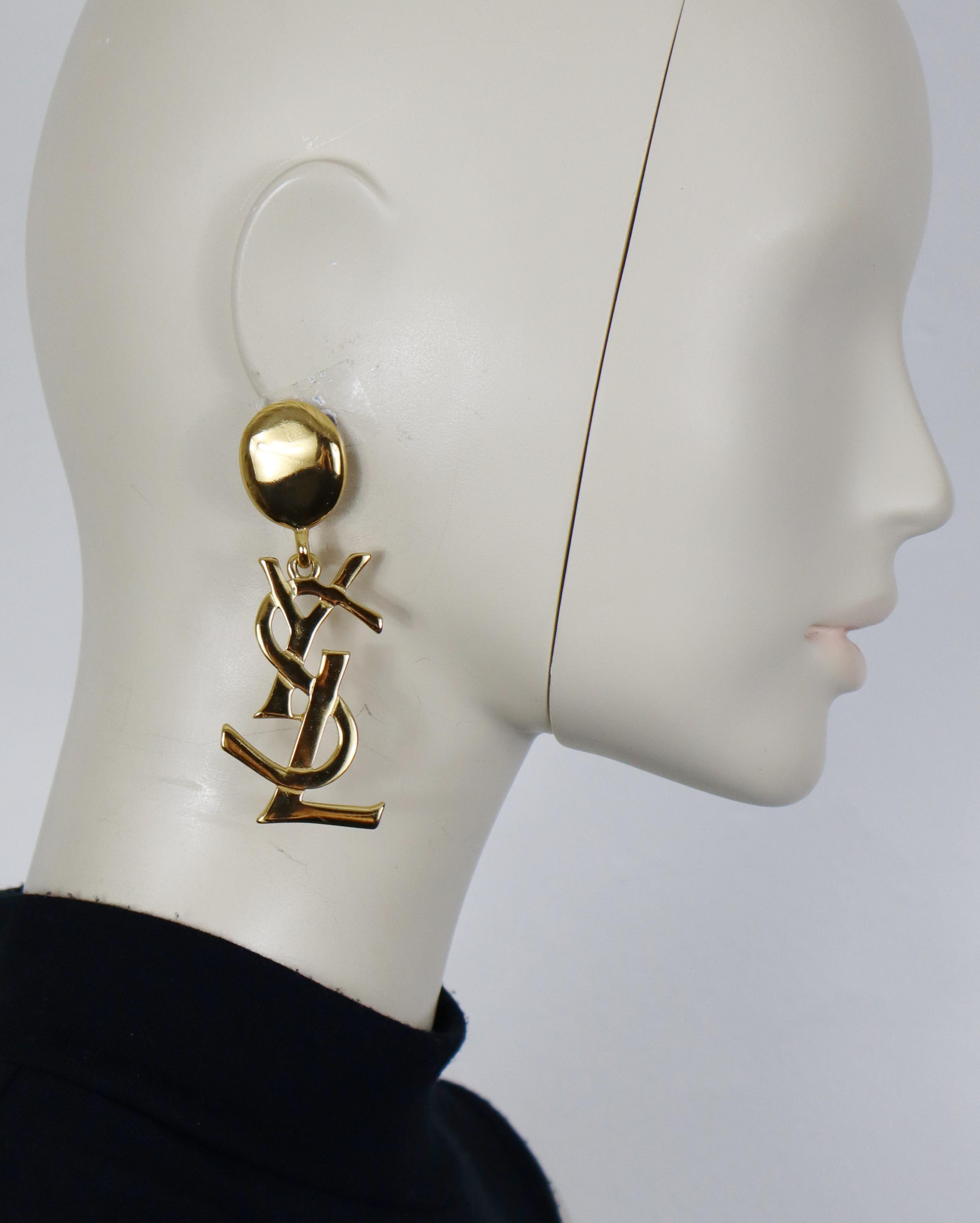 YVES SAINT LAURENT orecchini pendenti vintage in oro massiccio (a clip) con logo YSL.

YSL Made in France in rilievo.

Misure indicative: altezza circa 8,3 cm (circa 3,27 pollici) / larghezza massima circa 2,7 cm (1,06 pollici).

Peso per orecchino: