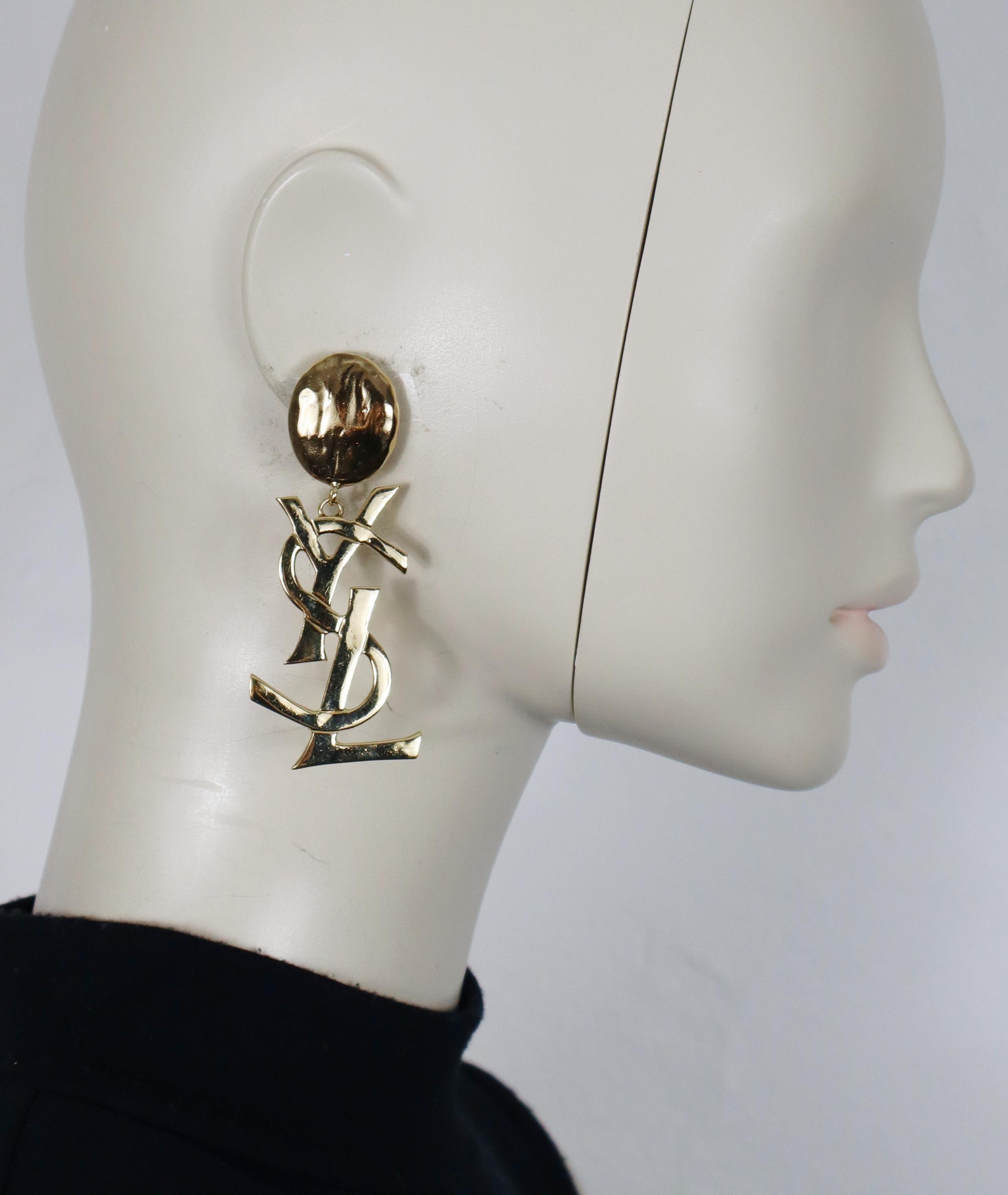 YVES SAINT LAURENT vintage massive gold tone iconic dangling earrings (clip on) featuring the YSL logo.

Embossed YSL.

Indicative measurements : height approx. 8 cm (approx. 3.15 inches) / max. width approx. 2.7 cm (1.06 inches).

Weight per