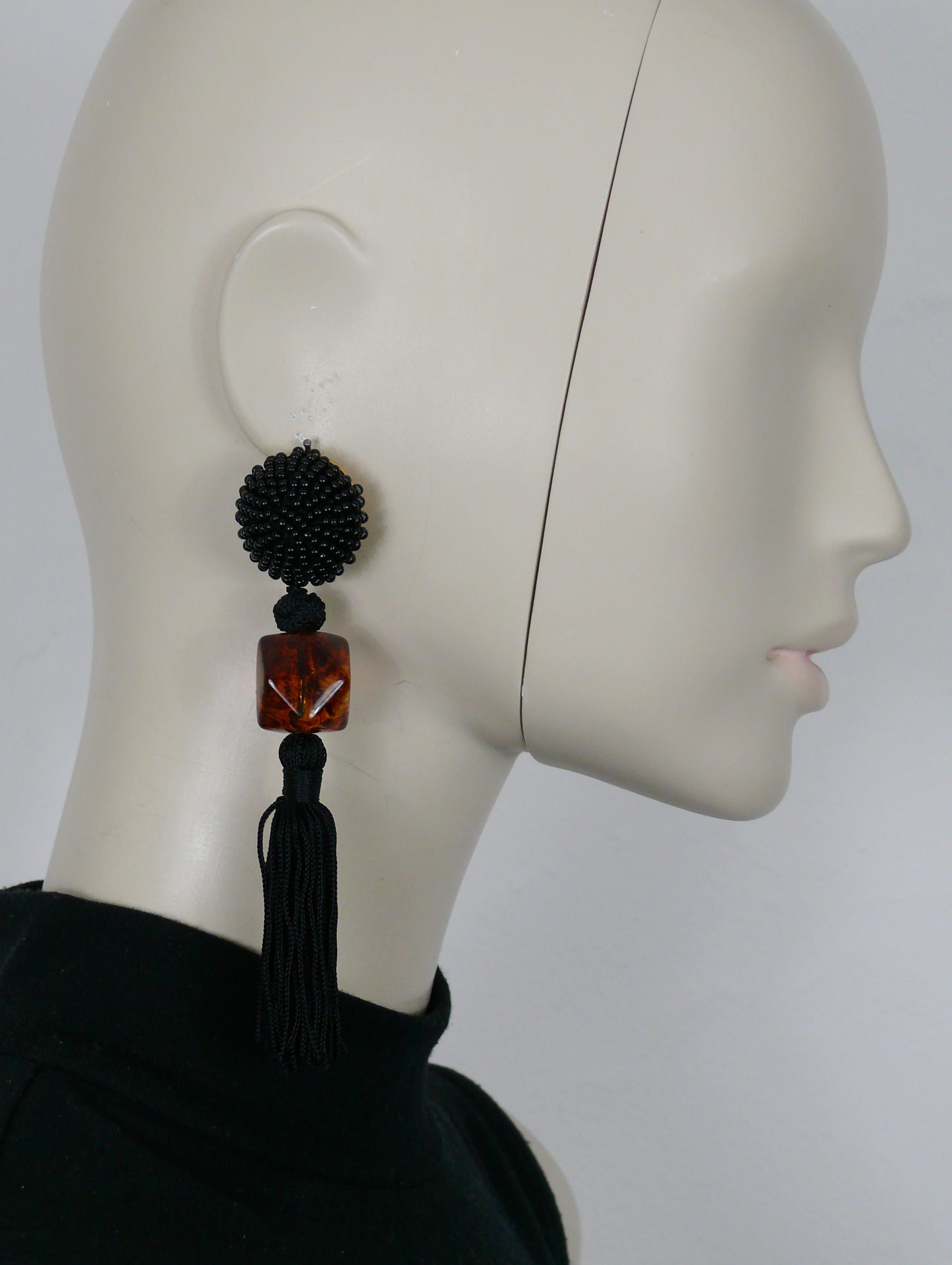 Boucles d'oreilles pendantes (clip-on) vintage d'Yves SAINT LAURENT, composées d'un top en perles noires, d'une grosse perle en résine multifacette et d'une pampille en passementerie noire.

Gaufrage YSL Made in France.

Mesures indicatives :