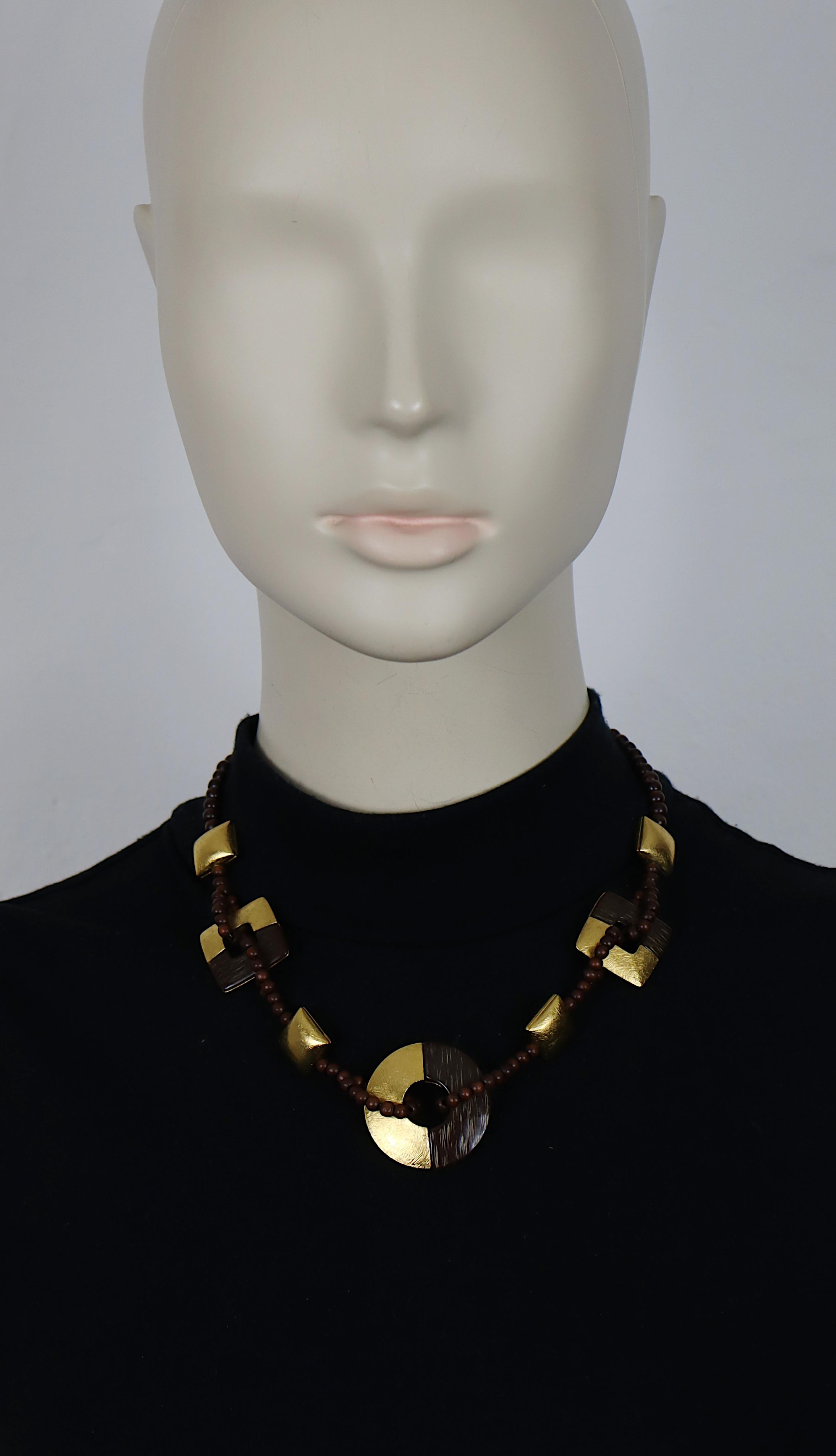 Collier de perles en bois vintage YVES SAINT LAURENT, composé de carrés et de disques texturés en ton or, certains agrémentés d'éléments en résine de faux bois.

Fermeture à boucle réglable.

Gaufrage YSL Made in France.

Mesures indicatives :