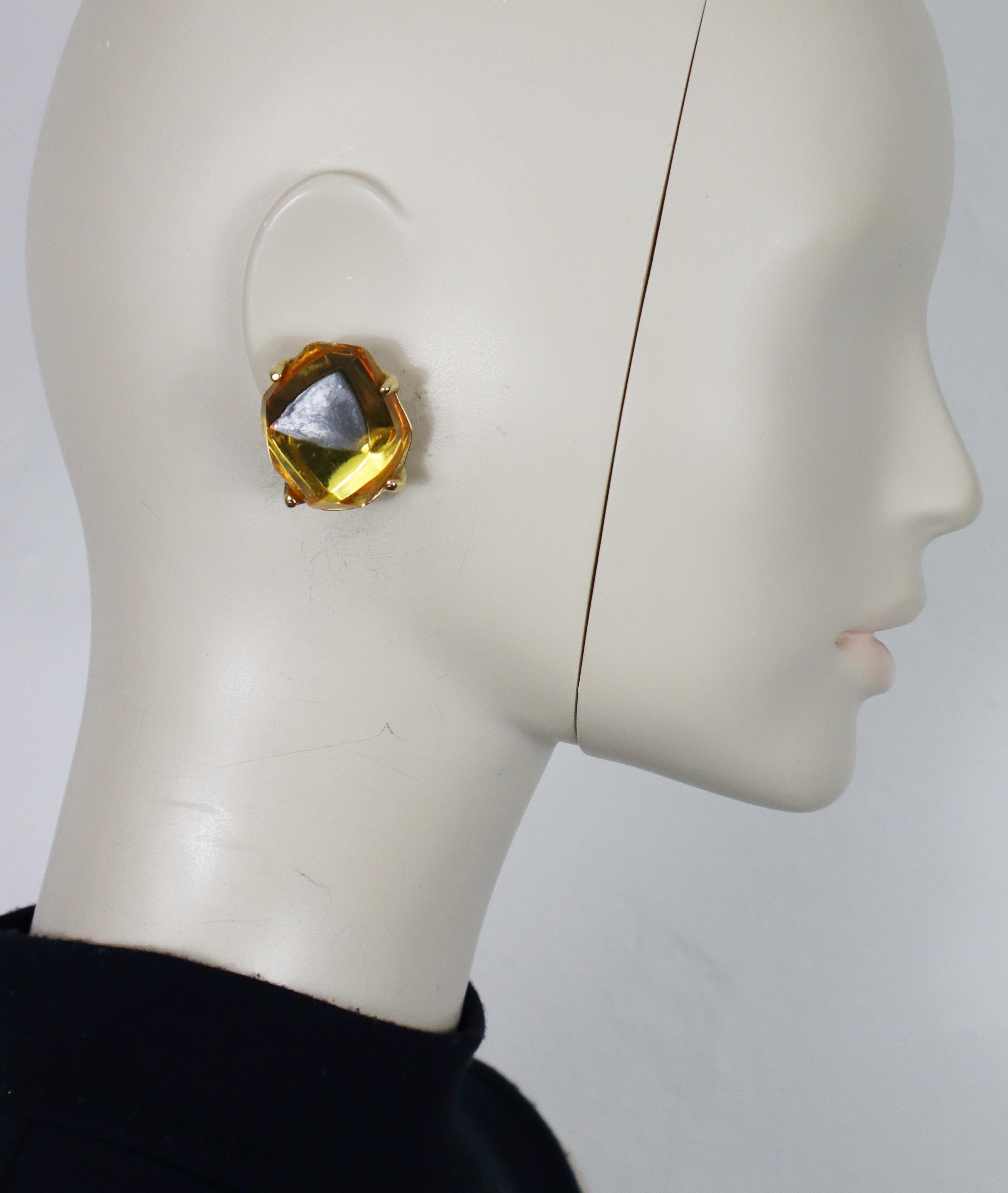 Boucles d'oreilles clips vintage en ton or d'Yves SAINT LAURENT, ornées d'un cabochon de résine jaune de forme irrégulière.

Gaufrage YSL Made in France.

Mesures indicatives : hauteur max. env. 3,5 cm (1.38 inches) / largeur max. env. 2,9 cm (1.14