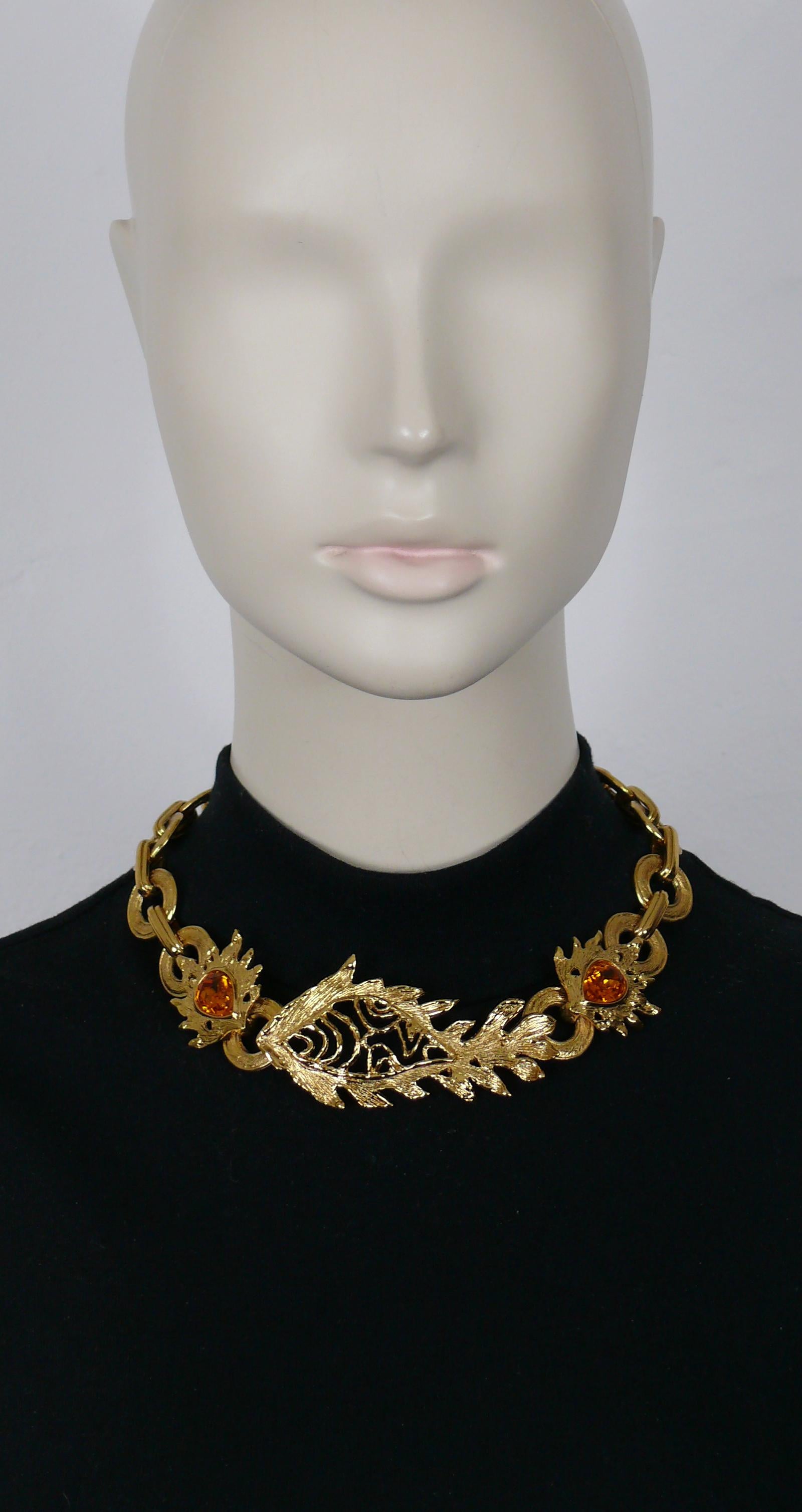 YVES SAINT LAURENT vintage gold tone necklace featuring an openwork fish centerpiece adorned with two large faceted pear-shape topaze color crystals.

Adjustable T-bar closure and love hearts toggles.

Cursive signature YVES SAINT LAURENT embossed