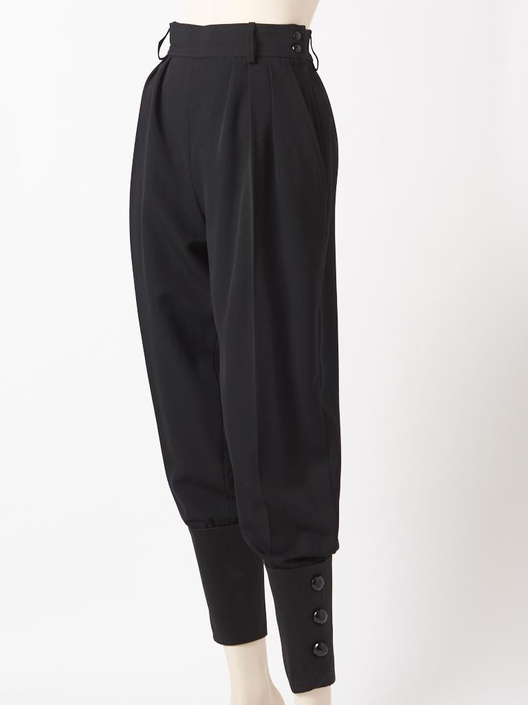 Yves Saint Laurent, Rive Gauche, black wool, Zouave, style pant having a side zipper closure, belt loops and pleated detail at the hip. Pant narrows at the ankle, in a satin fabric having faceted jet button closures.