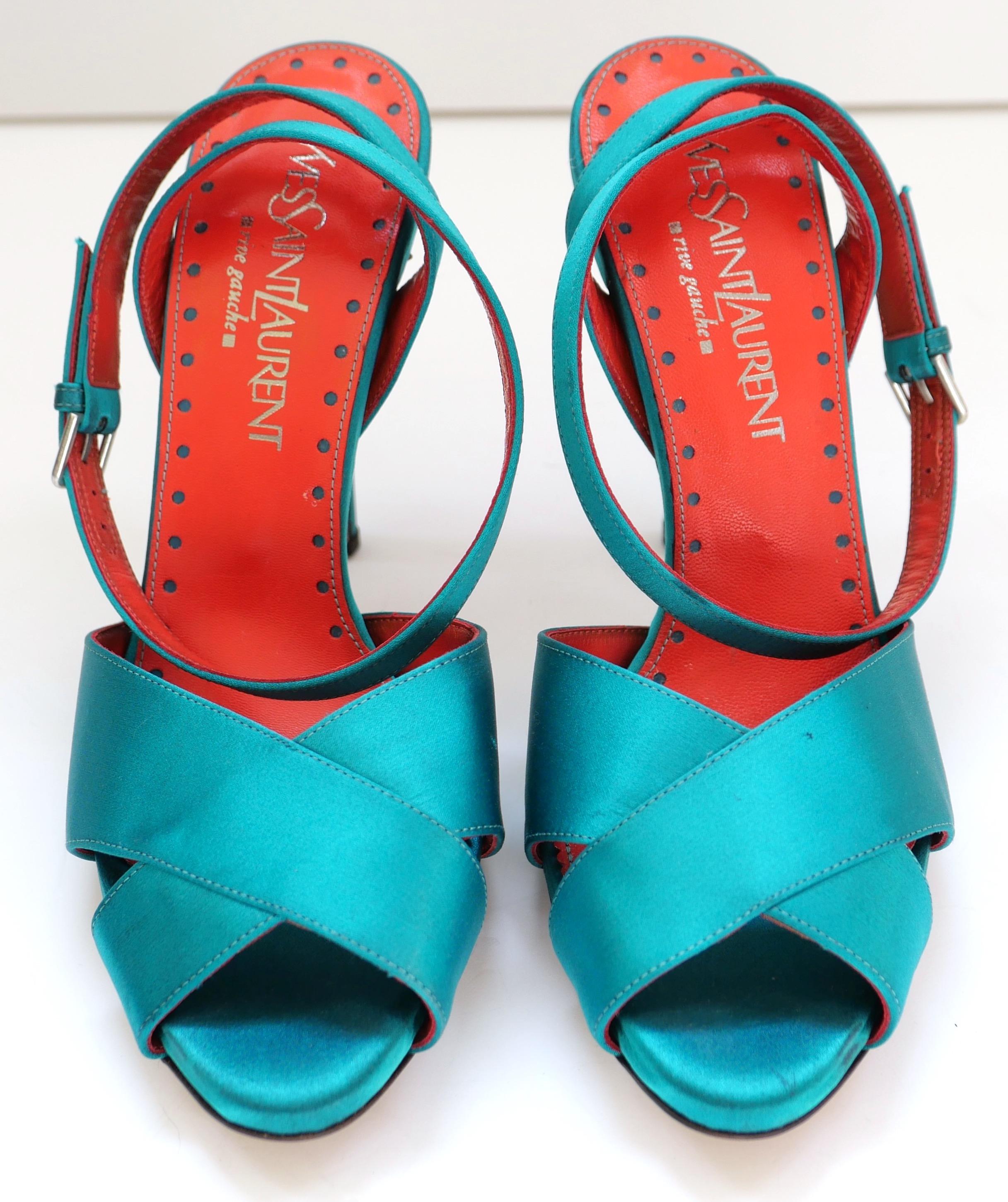 Stunning vintage Yves Saint Saint Laurent x Tom Ford teal satin heels. Made from smooth teal coloured satin, they have crossover fronts and wrap around ankle straps with silver tone buckles. Have decorative red leather footbeds. Unworn but have some