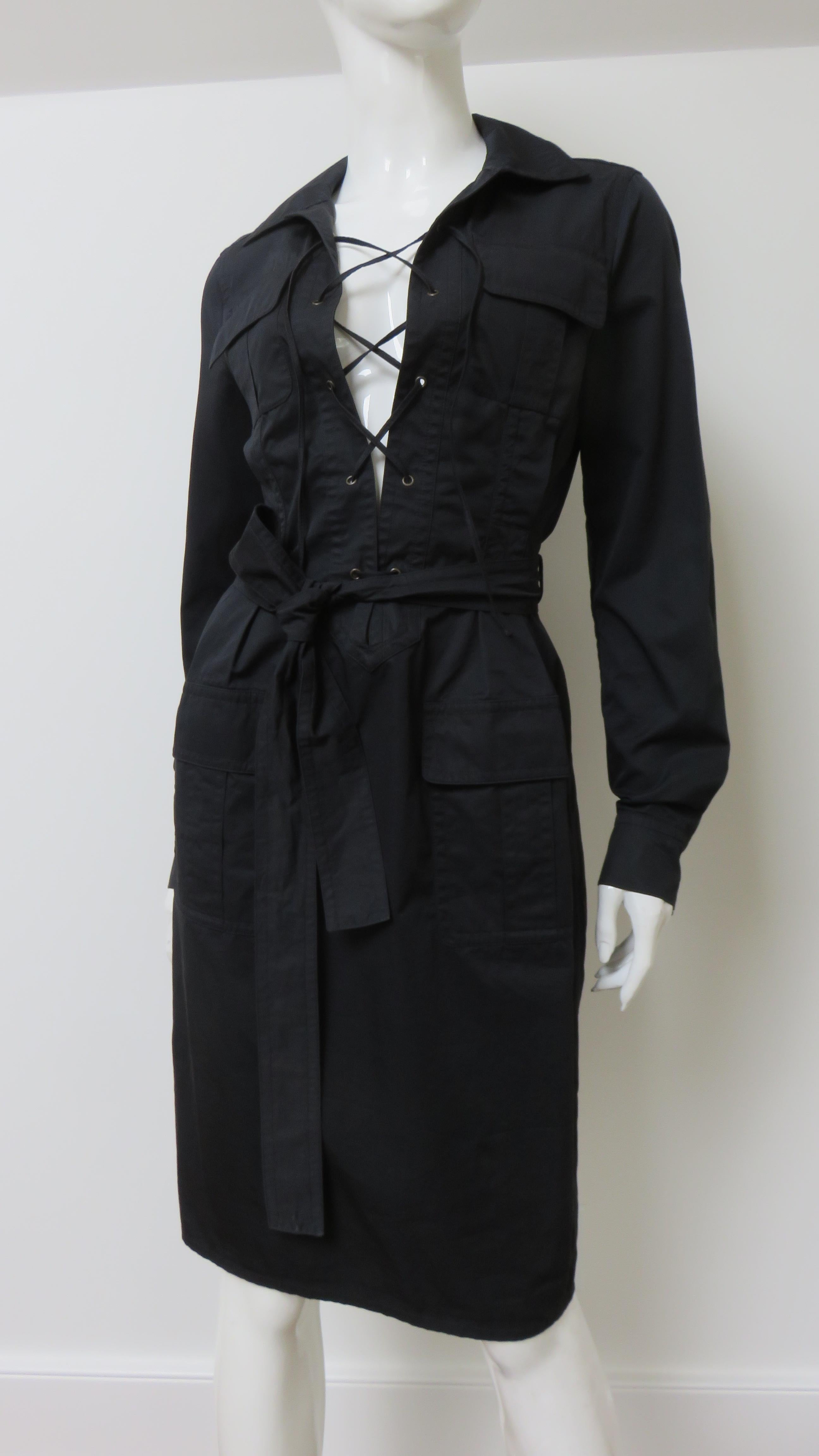 A fabulous fine black polished cotton dress by Tom Ford for Yves St. Laurent.  As a nod to St. Laurent's notable 1968 safari collection it has a similar features- shirt collar, 4 front flap patch pockets, and long sleeves with button cuffs and