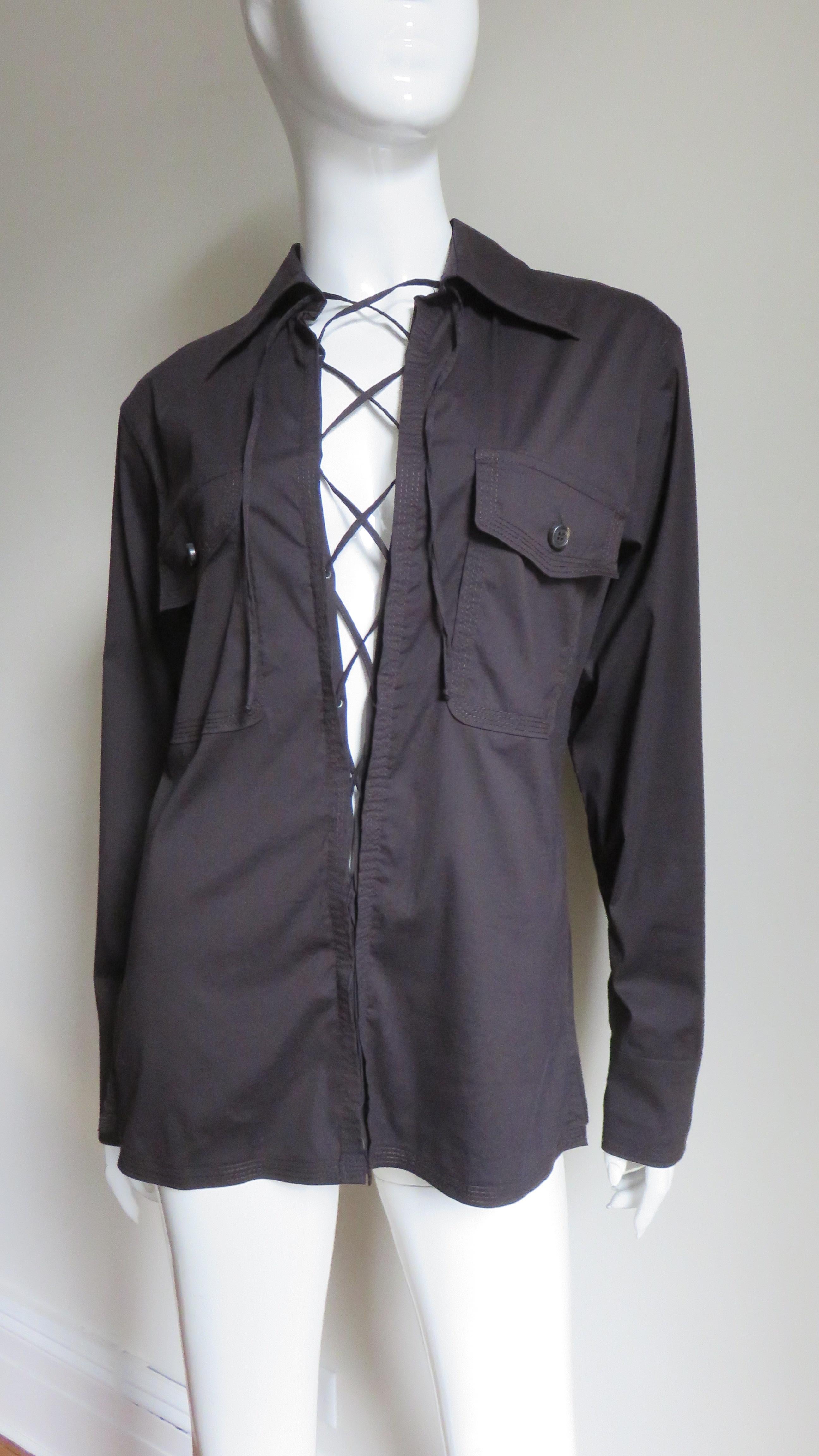 A rich brown fine cotton shirt from Tom Ford for Yves St Laurent, YSL.  It has a shirt collar, button flap front patch chest pockets, a back yoke, and matching button cuffs. There is elaborate functional, adjustable lacing along the center front. 