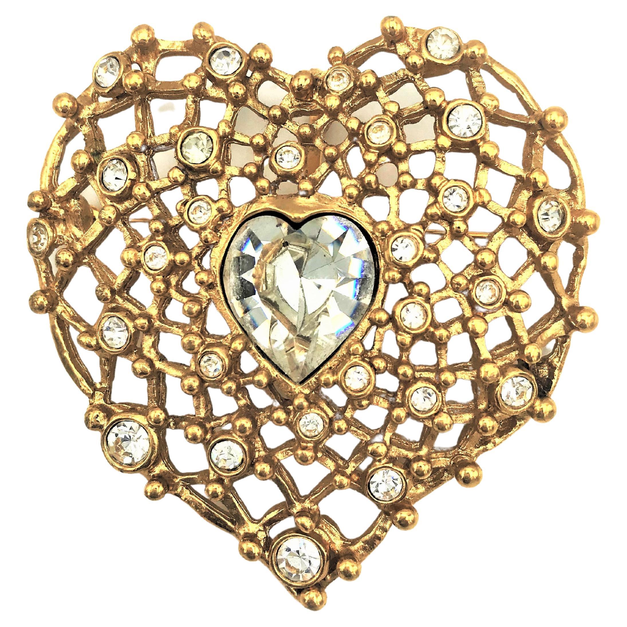 YSL Paris brooch can also be worn as a pendant in the shape of a heart. The heart is perforated like a grid, with many small and large rhinestones. Centrally large cut heart-shaped rhinestone. To wear a very nice brooch on the lapel of a Sacco or on