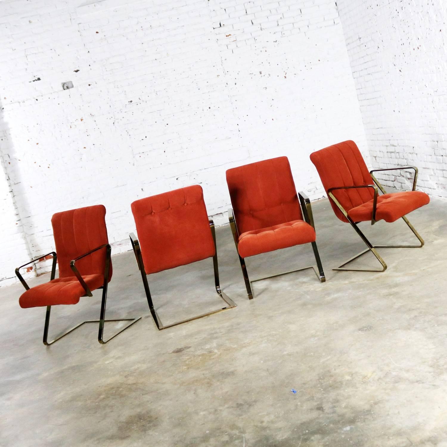 Handsome set of four Z frame cantilevered Milo Baughman style dining chairs in burnt orange velvet and brass plated flat bar frames. They are in wonderful vintage condition. The brass plating has minor scratching and may have some minor spots where