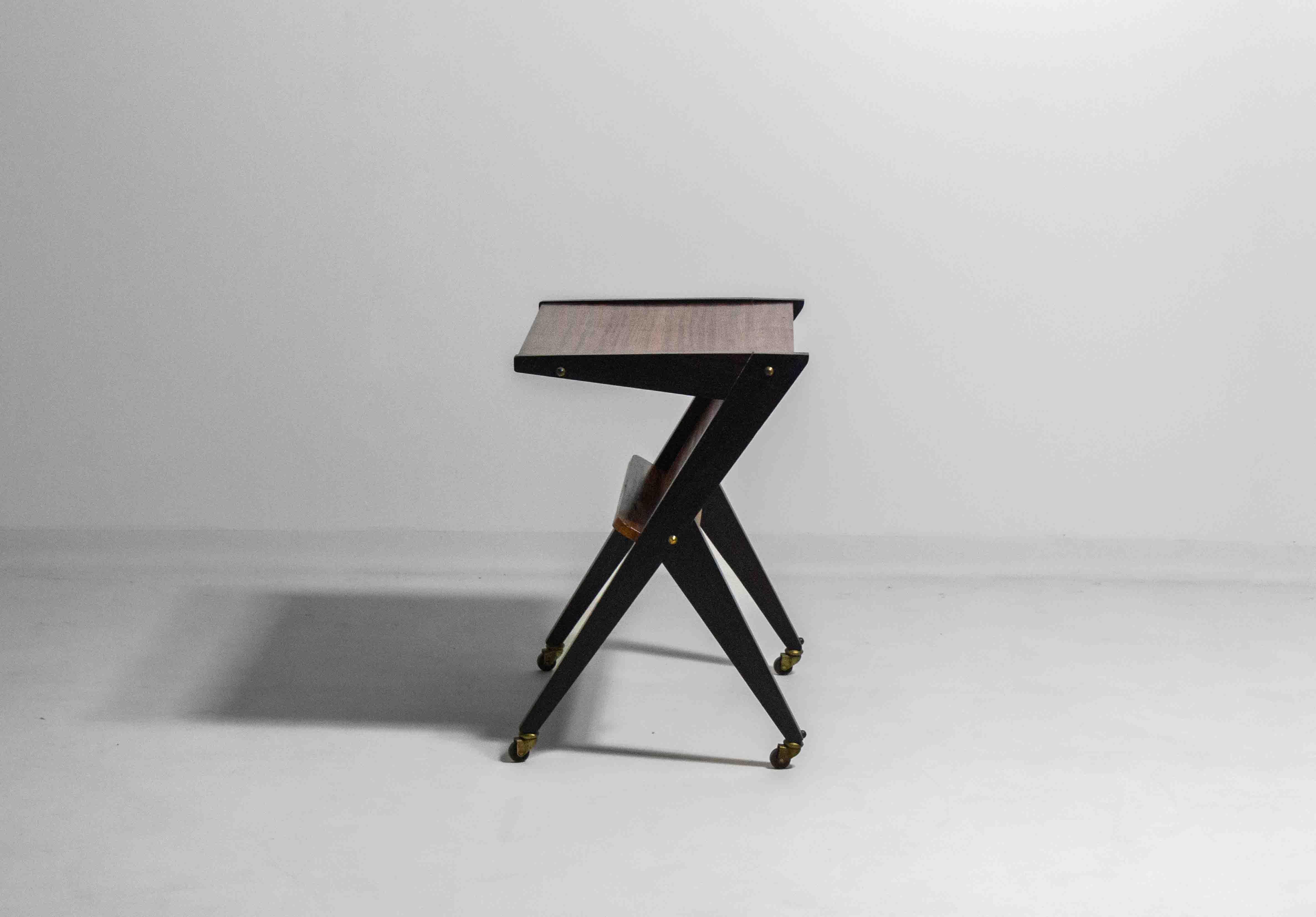 Questo straordinario carrello da bar della metà del secolo scorso, originariamente progettato come supporto per la televisione da Téléavia negli anni '60, presenta un'audace struttura a forma di Z in legno tinto scuro con eleganti accenti in ottone.