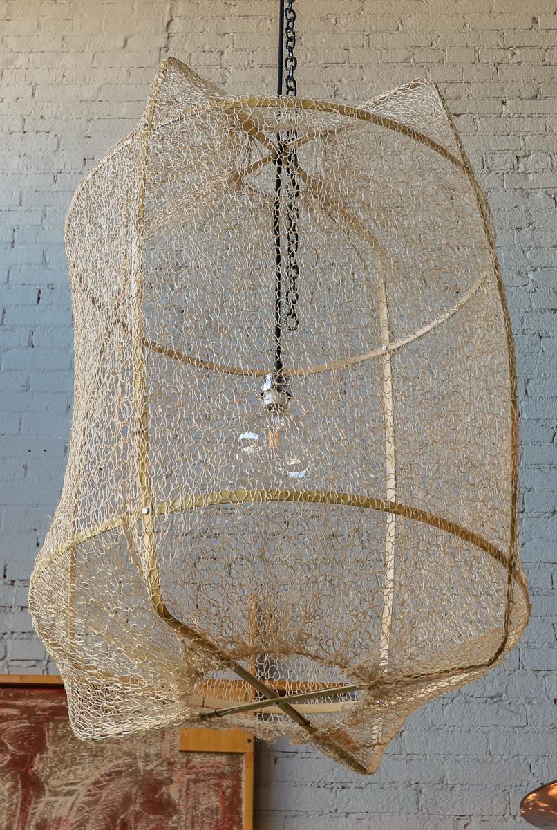 The Z2 blond Sisal net pendant has a handcrafted blond bamboo frame, which is sheathed in an infinite swath of hand-knitted sisal from Swaziland, the fabric shades created in local collaborative workshops by women whose lives are being uplifted by