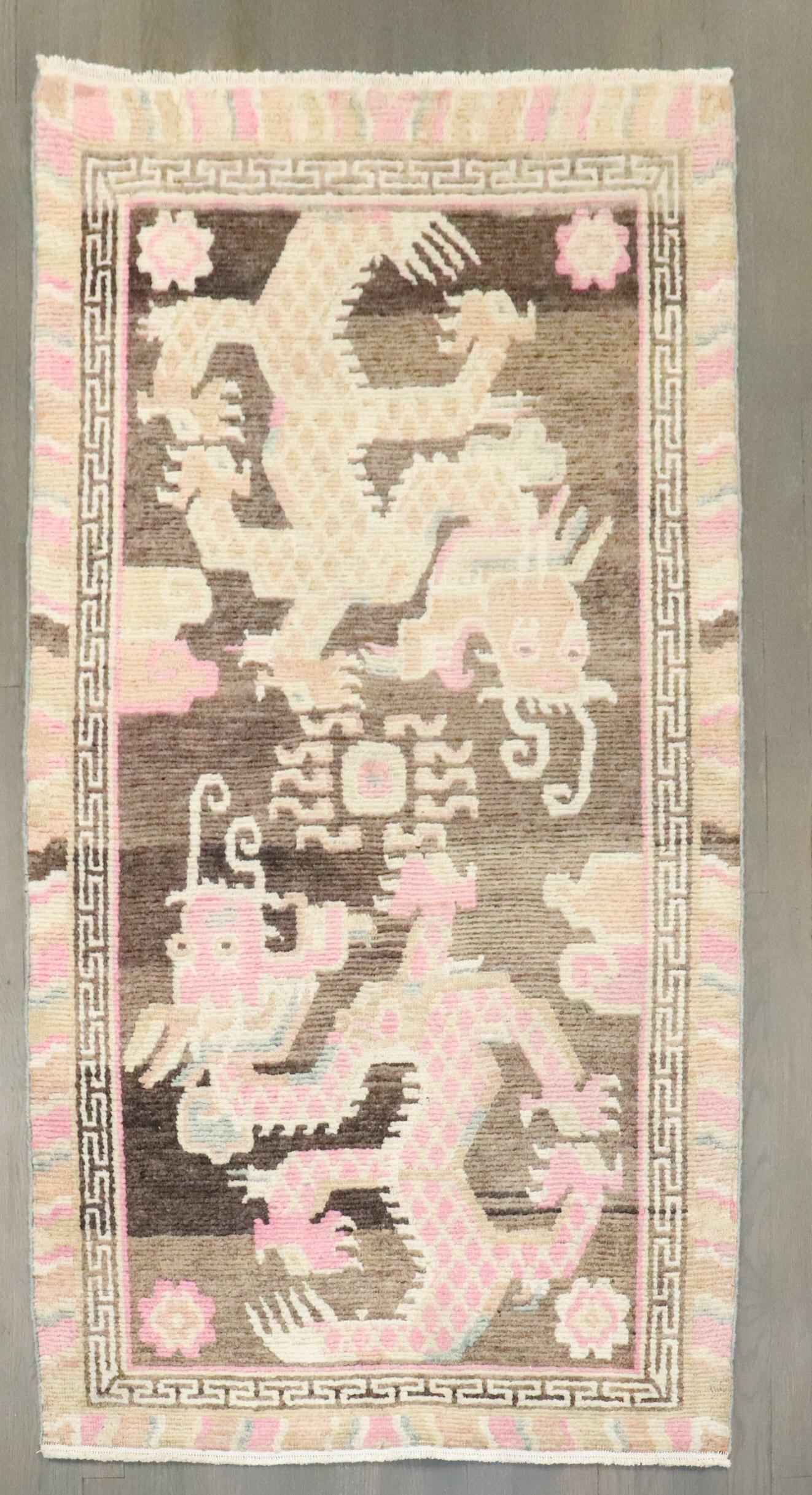 A 2nd quarter of the 20th-century feminine colored Tibetan rug with a dragon motif on a brown color field.

Size: 3'1'' x 5'7''.

