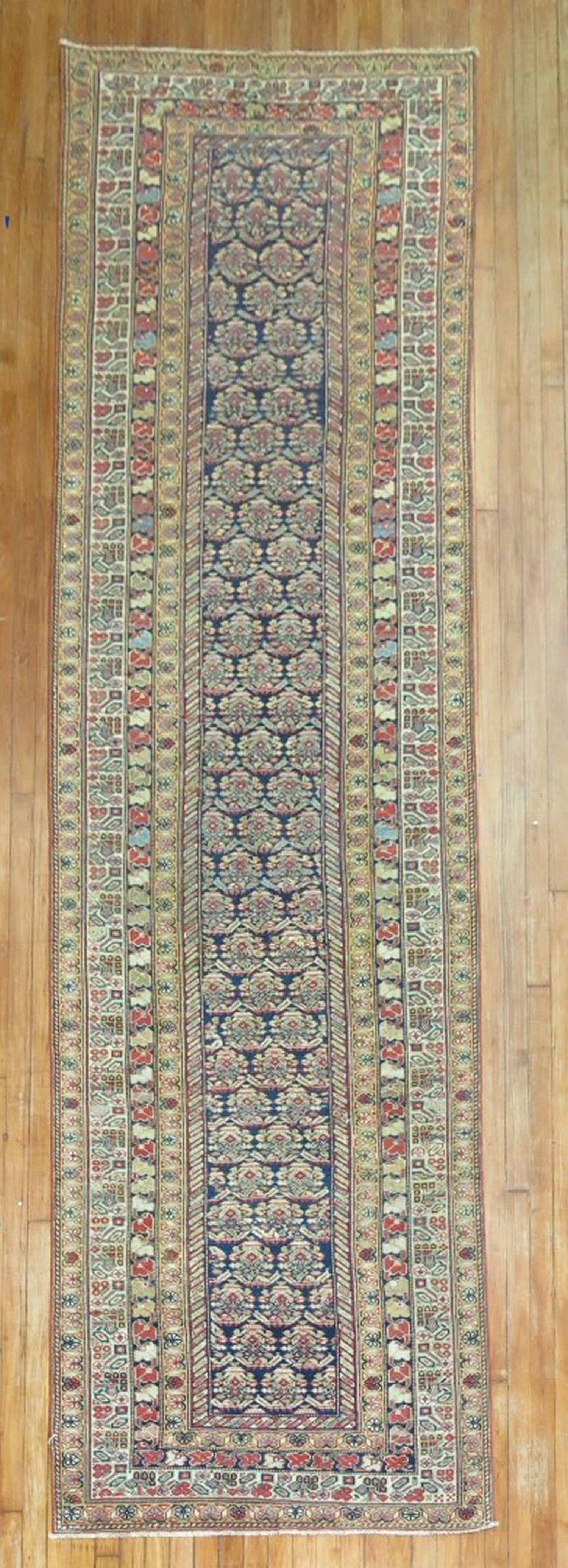An authentic early 20th century Fine Persian Ferehan runner sporting a classic repetitive paisley motif on a navy field. 

Measures: 3'6