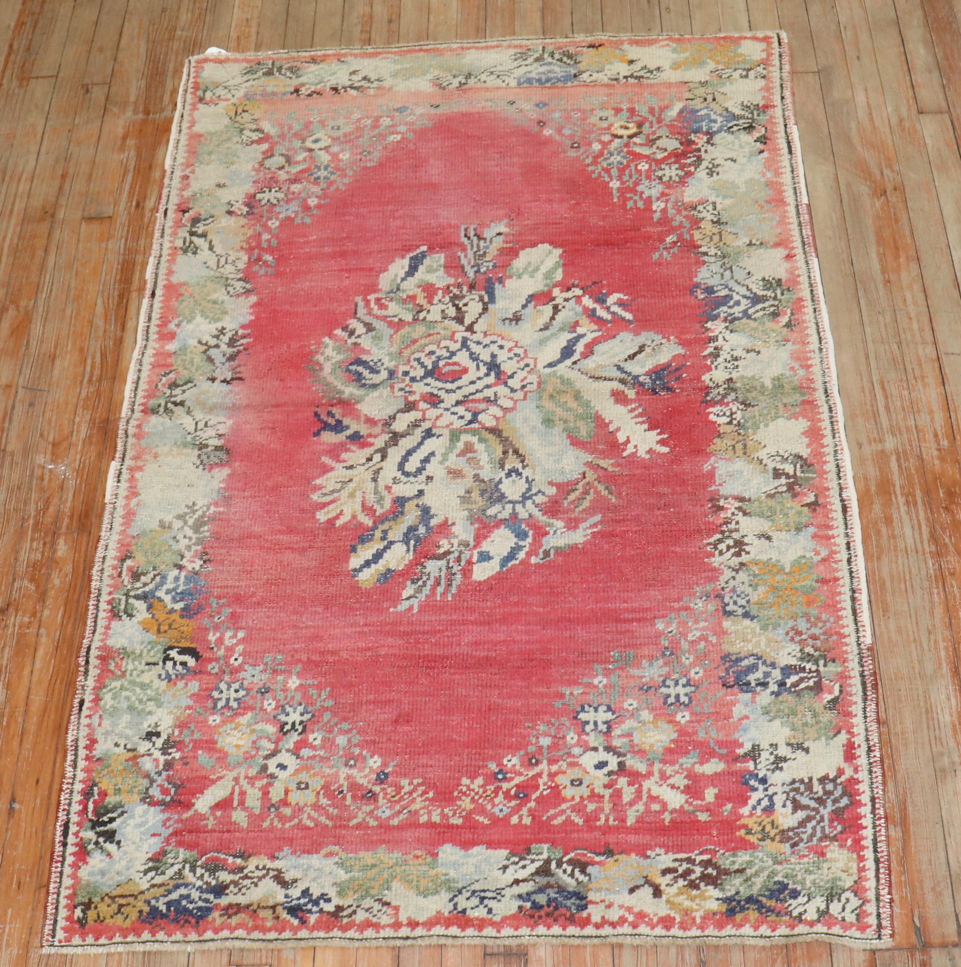 An early 20th-century floral motif Turkish Ghiordes rug in pink.

3'11'' x 5'11''