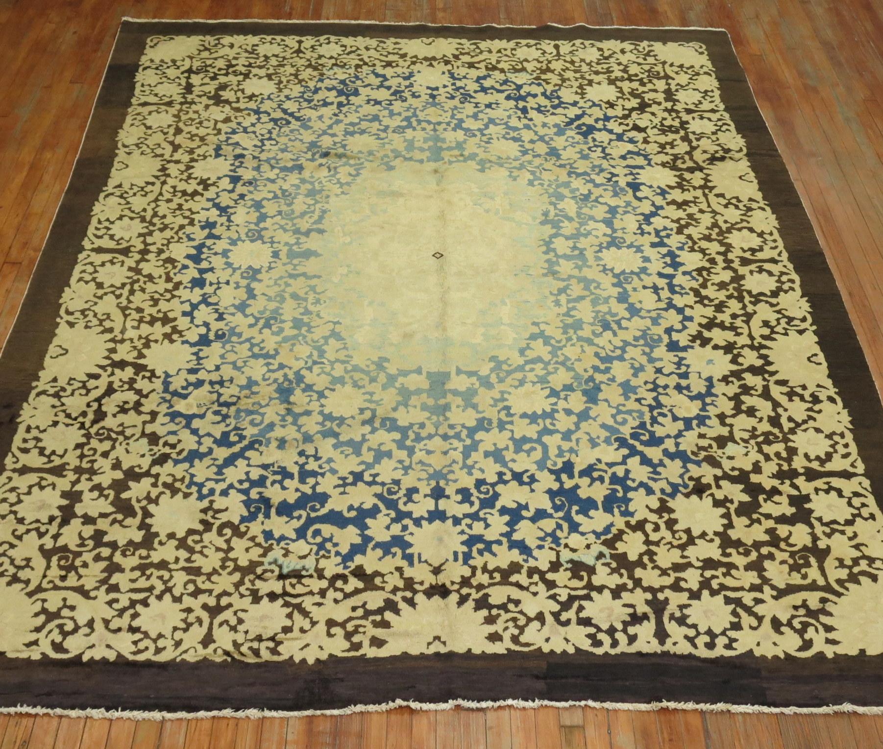 an early 20th Century Chinese rug with a floral design in cream, blue, yellow and brown

Measures: 8'11'' x 11'5''.