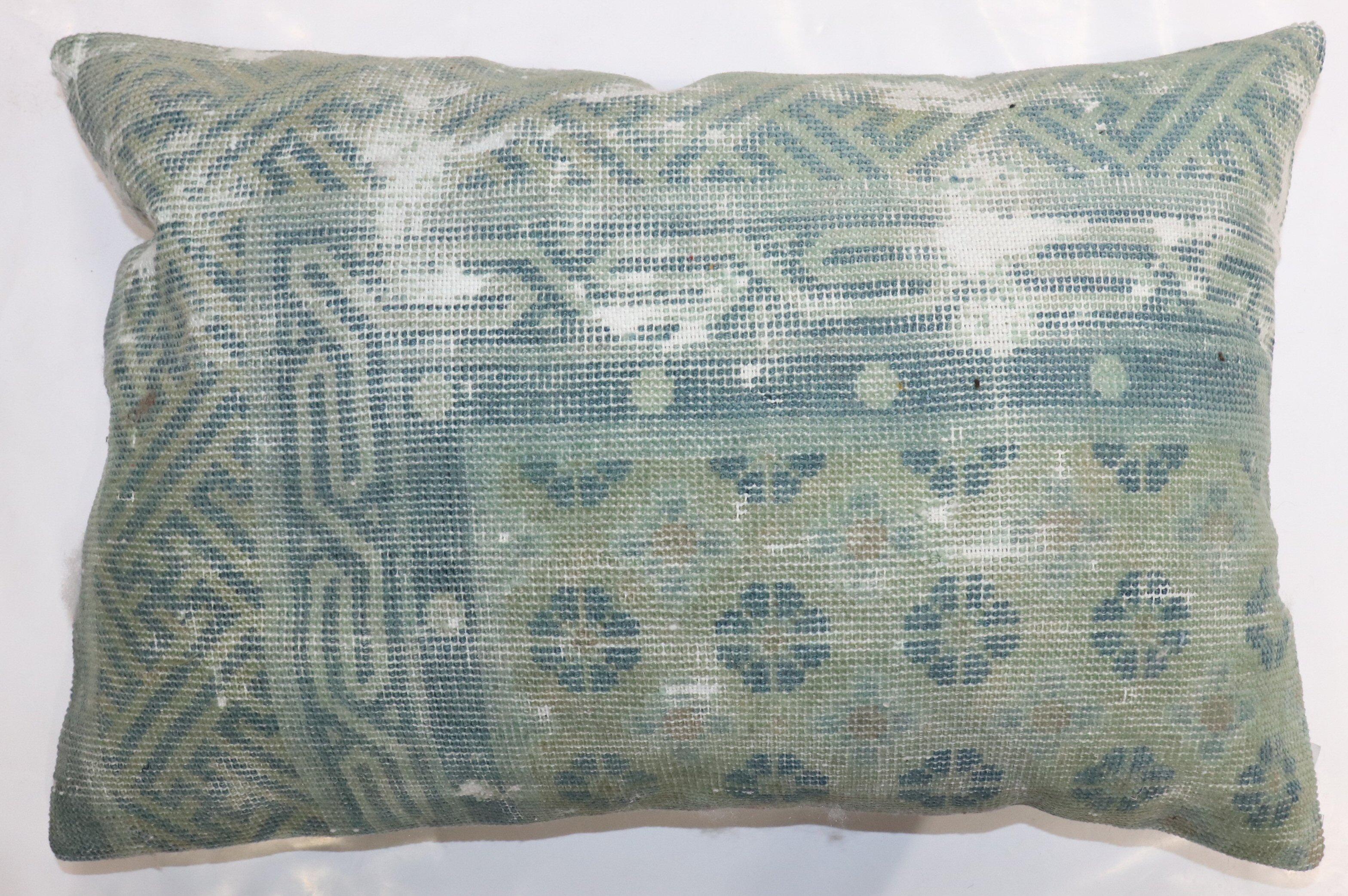 A pillow made from a worn 19th-century antique Chinese rug.

16'' x 24''