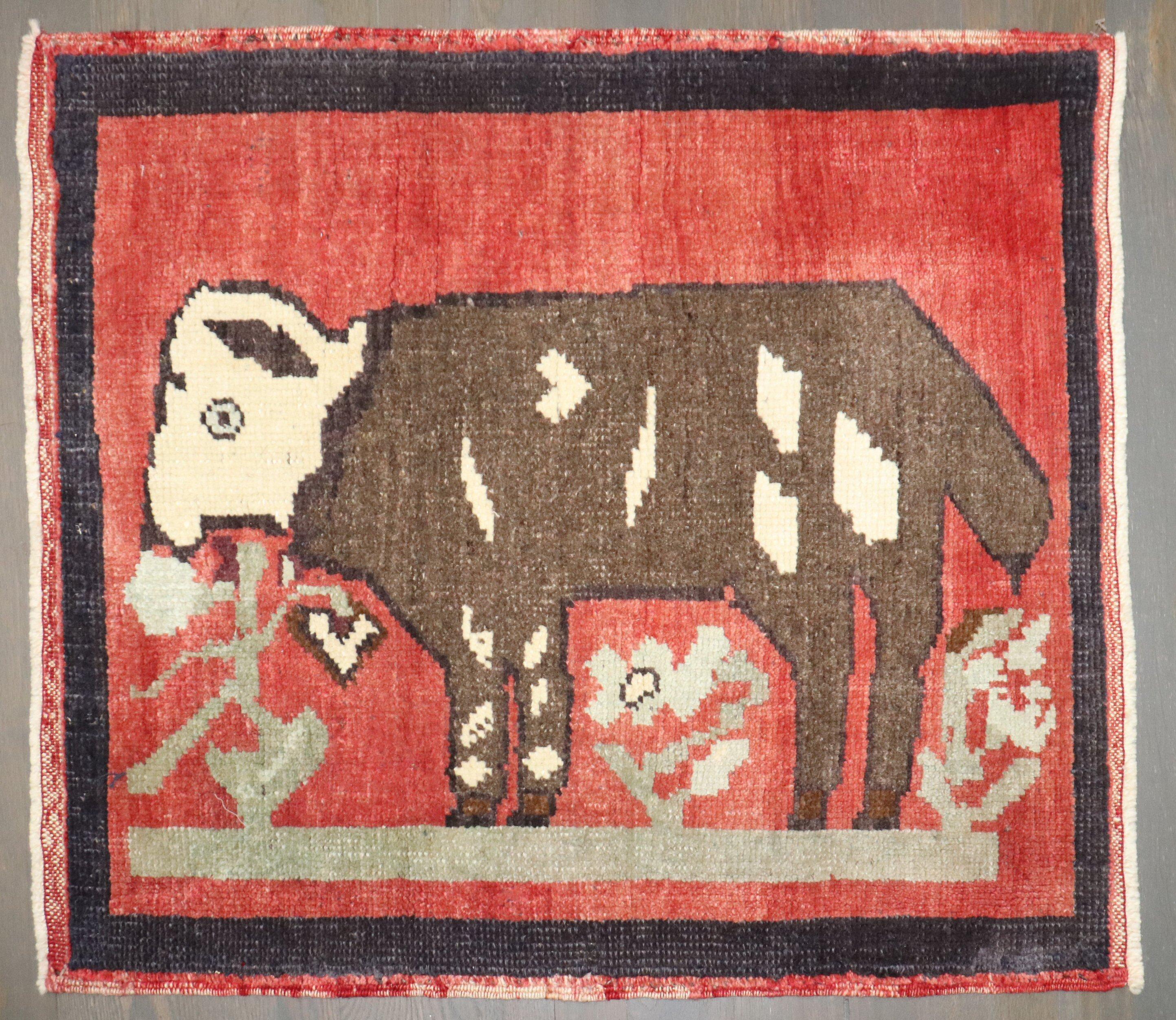 A cute one of a kind Mid-20th Century Hand-knotted Turkish Anatolian Pictorial small square rug depicting a llama goat on a red field

Measures: 2'8'' x 2'10''
