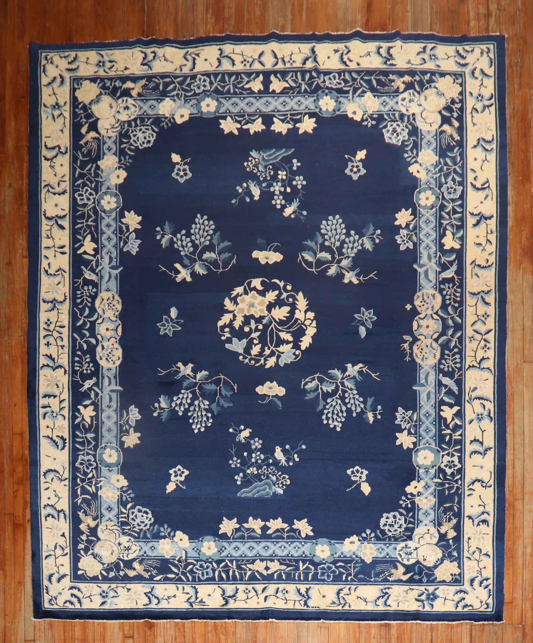An authentic early-20th-century Chinese rug with a spacious open field floral design on a navy ground.

Measures: 8'11'' x 11'6''.
