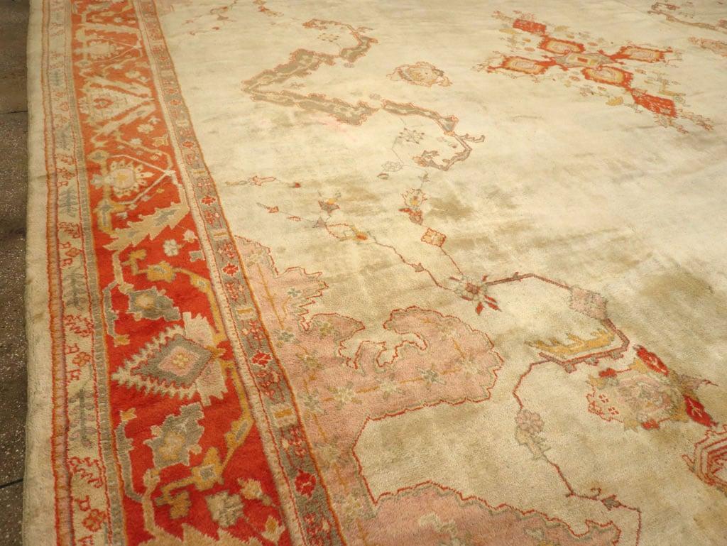 ein antiker Oushak-Teppich in Elfenbeinfeldgröße aus dem frühen 20.

Einzelheiten
Teppich nein.	10826
Größe	19' 6